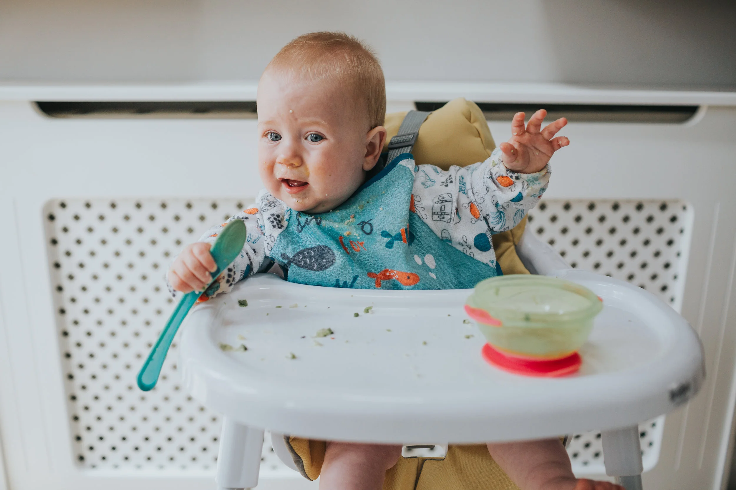 Baby uses his spoon as a microphone. 