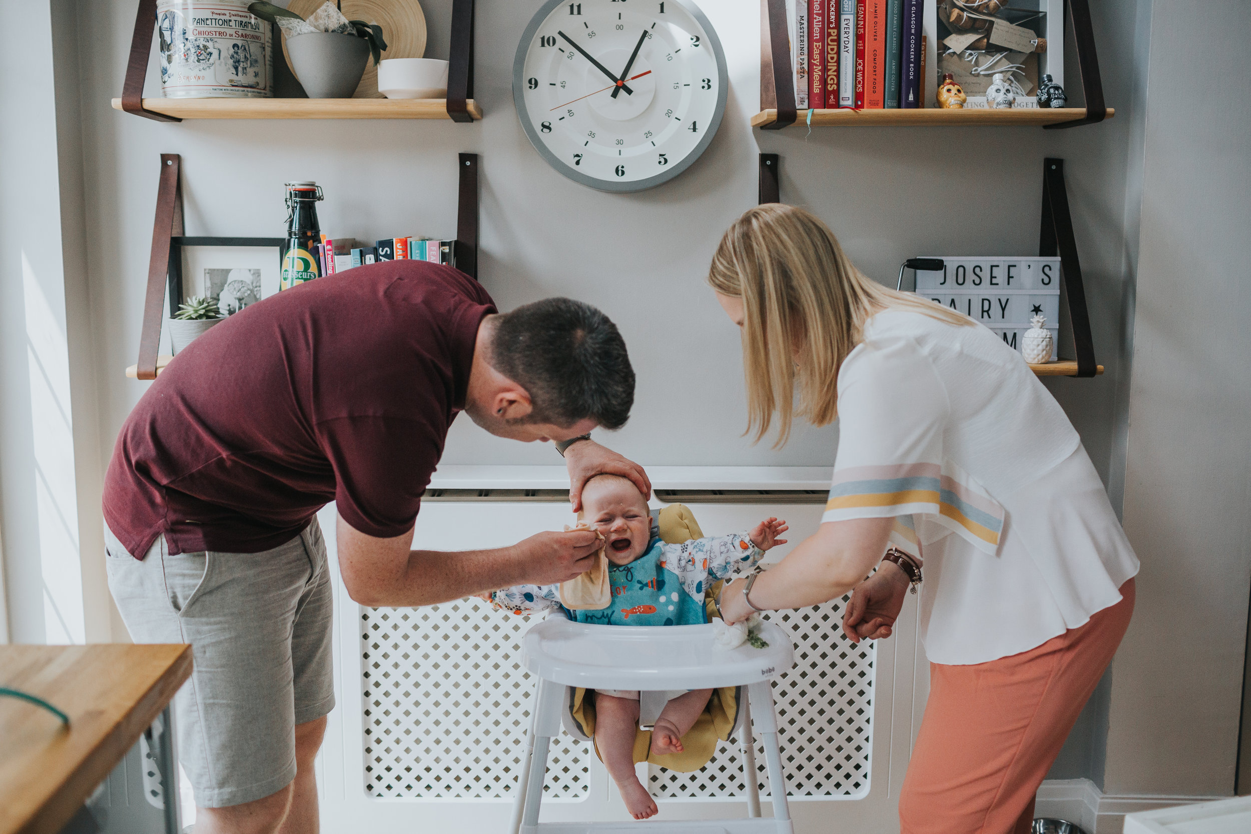 Mum and Dad clean babies face and the baby cries. 