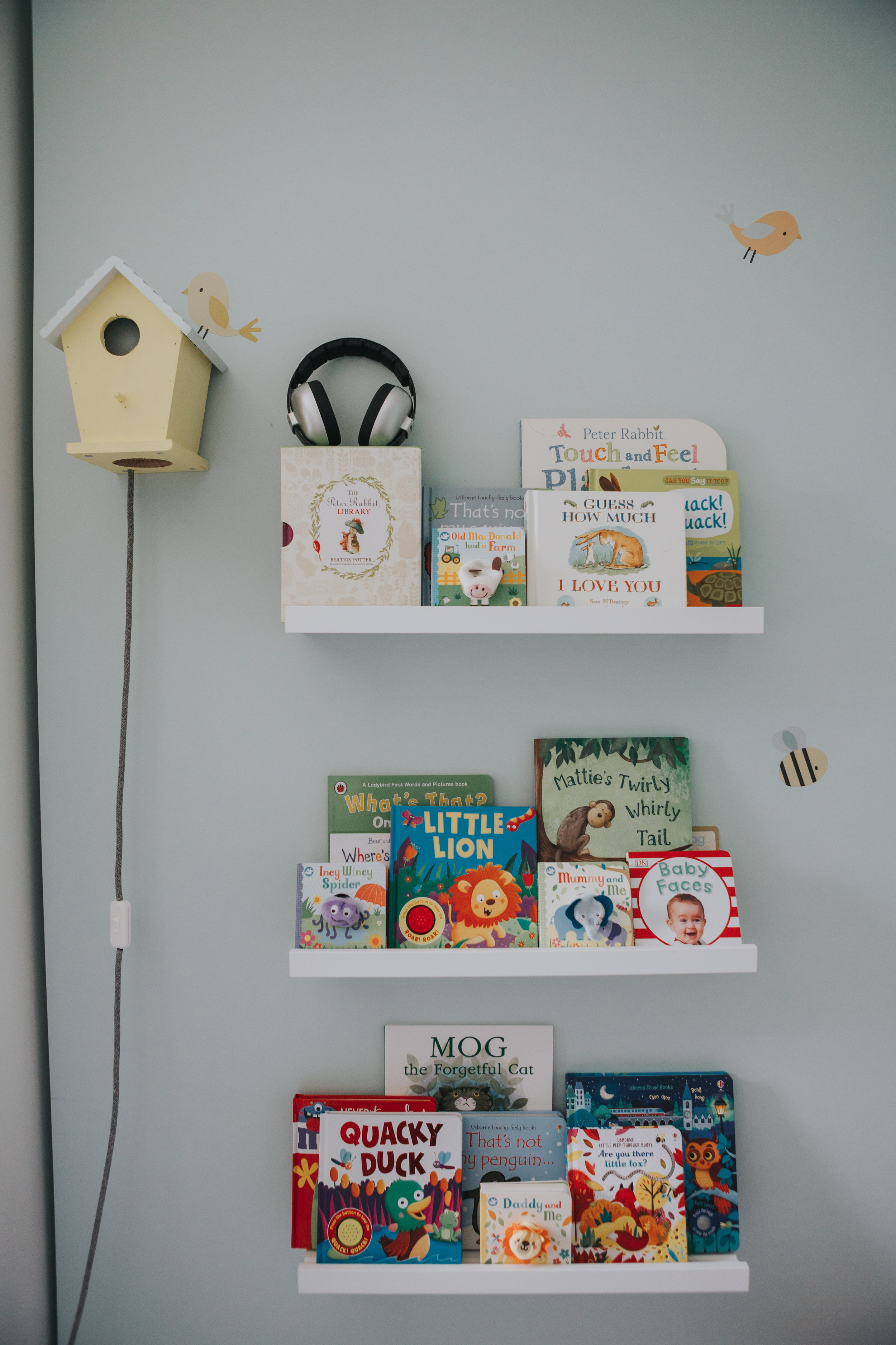 Bird house and book shelves in babies room. 