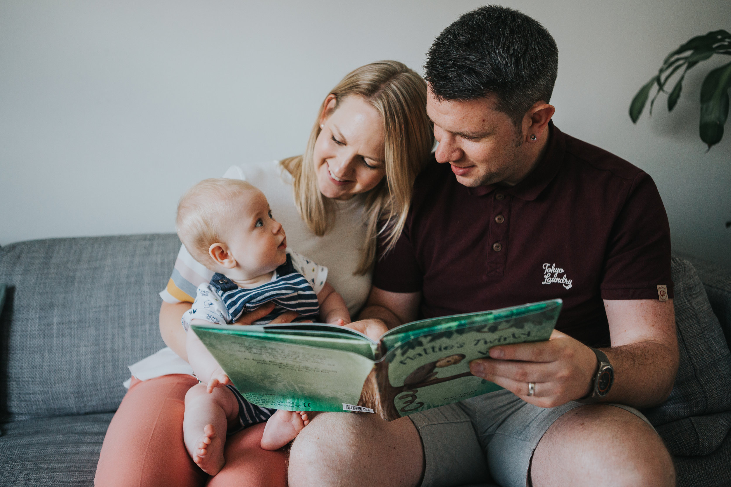 Baby being read a story sitting on his mums knee.