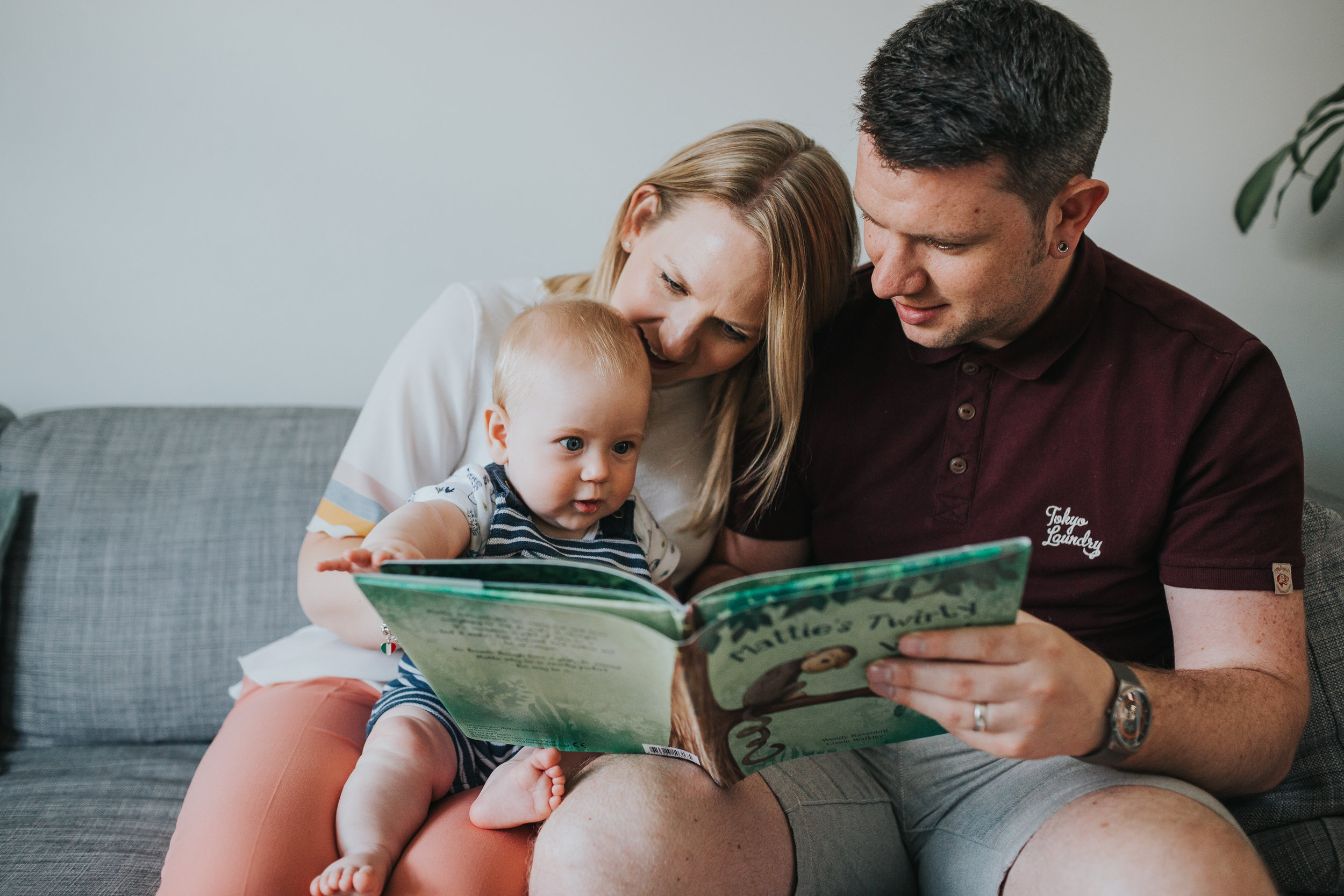Baby sitting on his mums lap being read a story.
