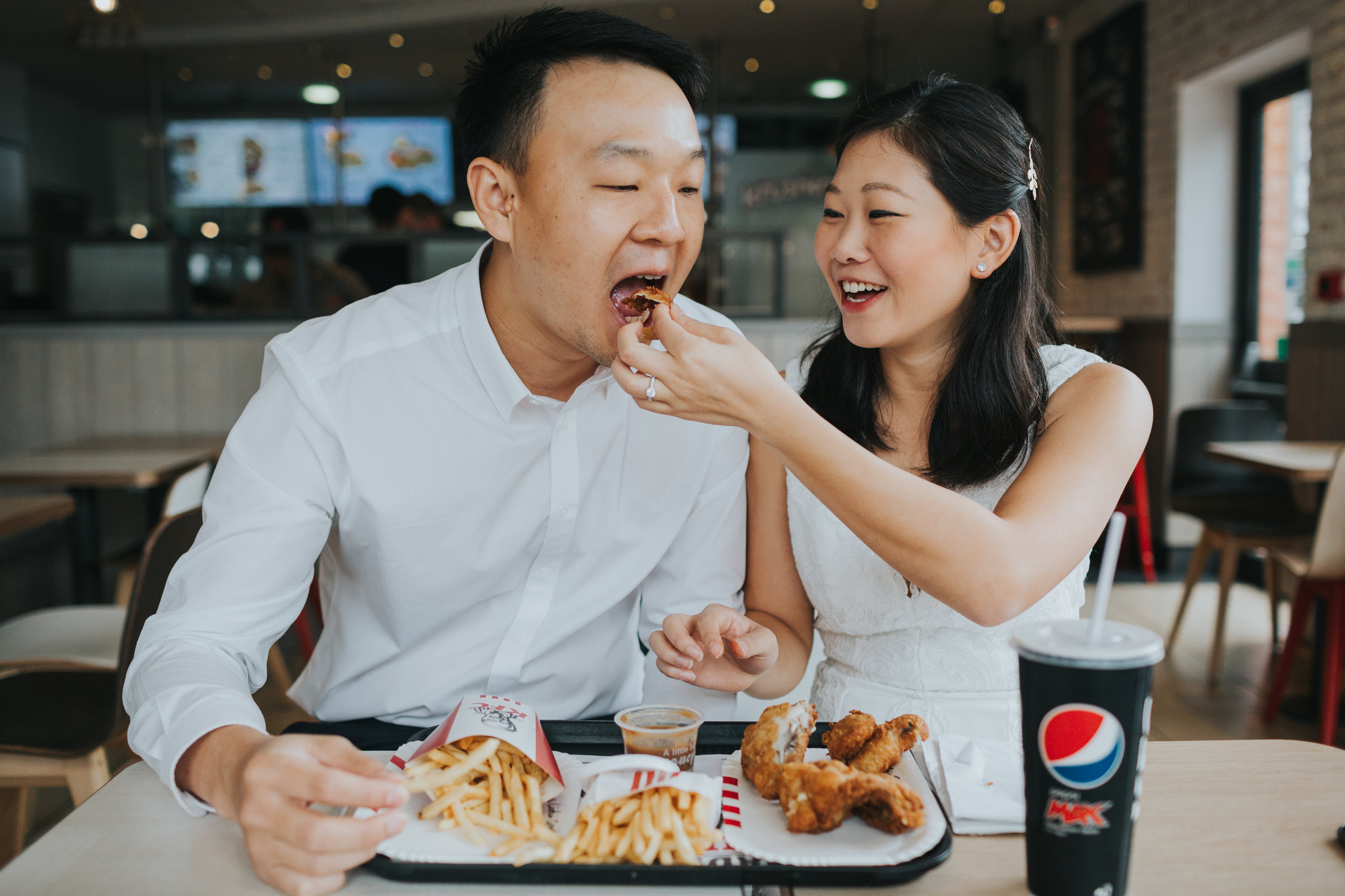 Couple feed each other chicken in KFC. 