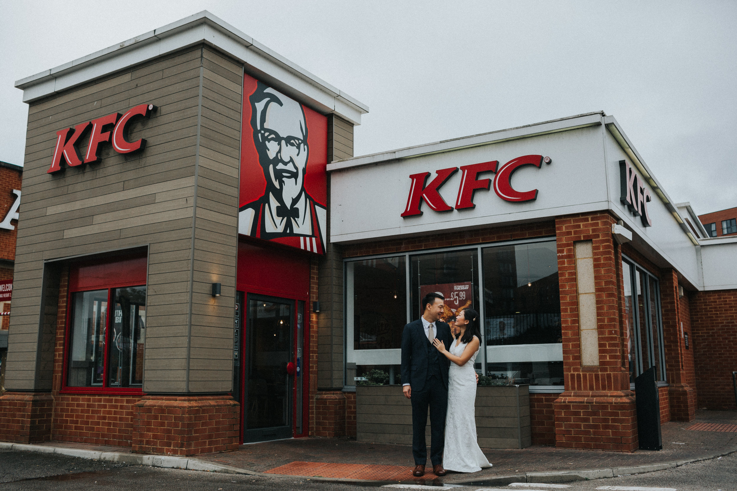 Couple embrace outside KFC. 