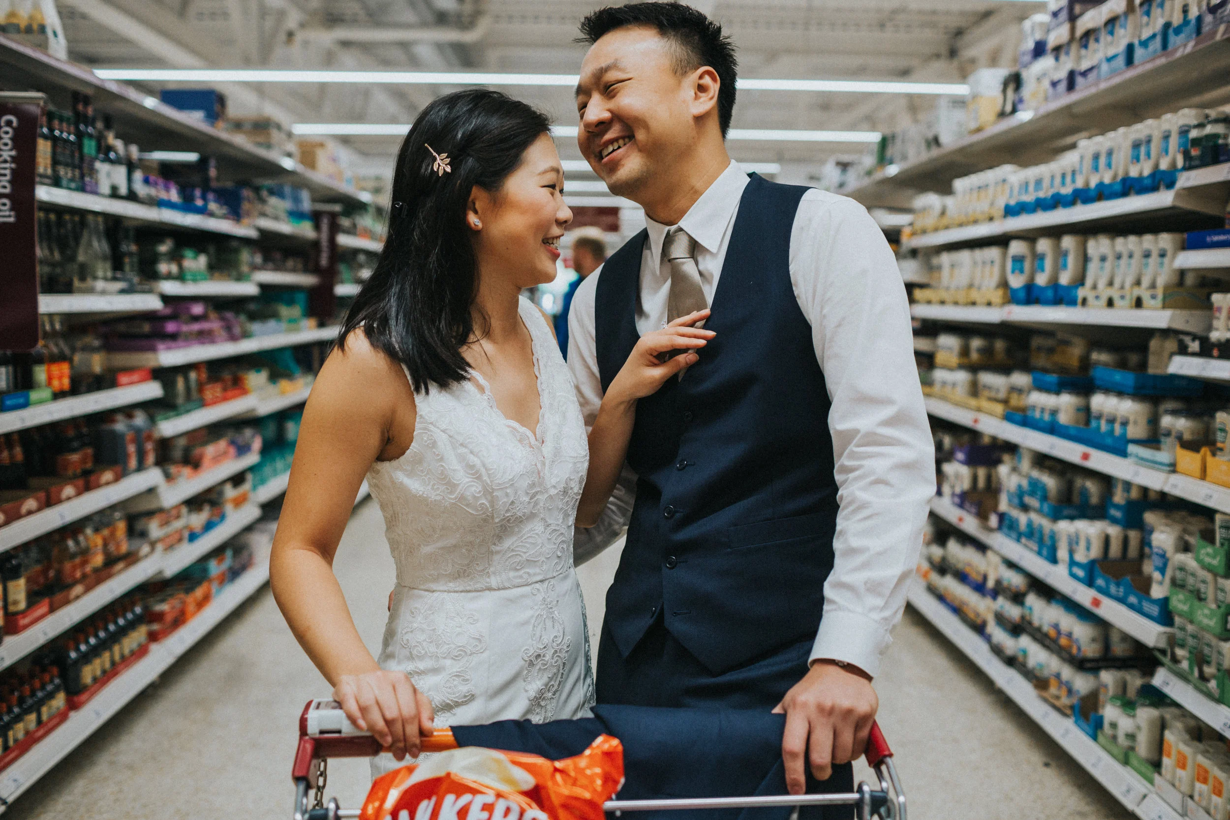 Bride fixing Grooms tie in supermarket. 