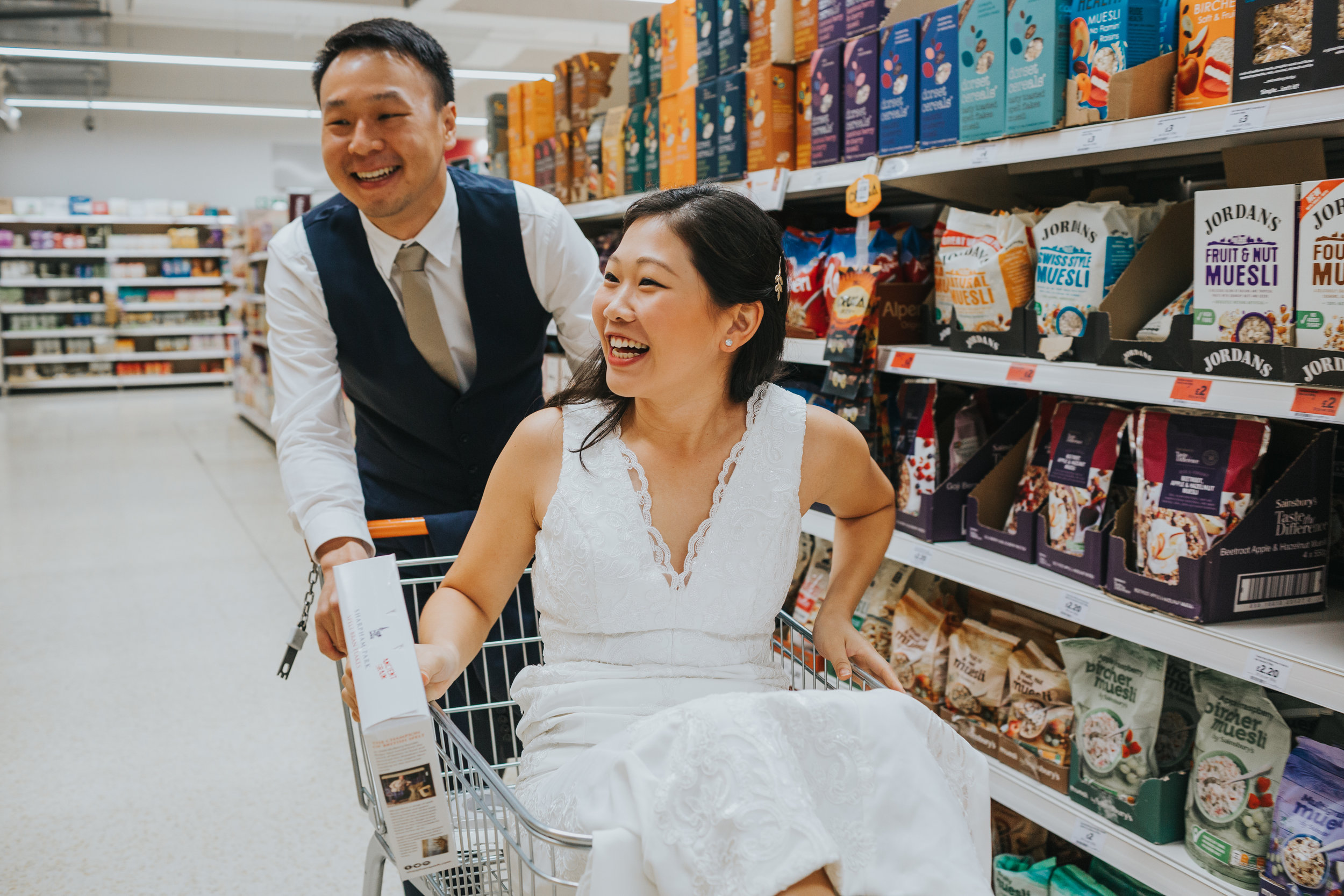 Groom pushes bride down the aisle in shopping trolley. 