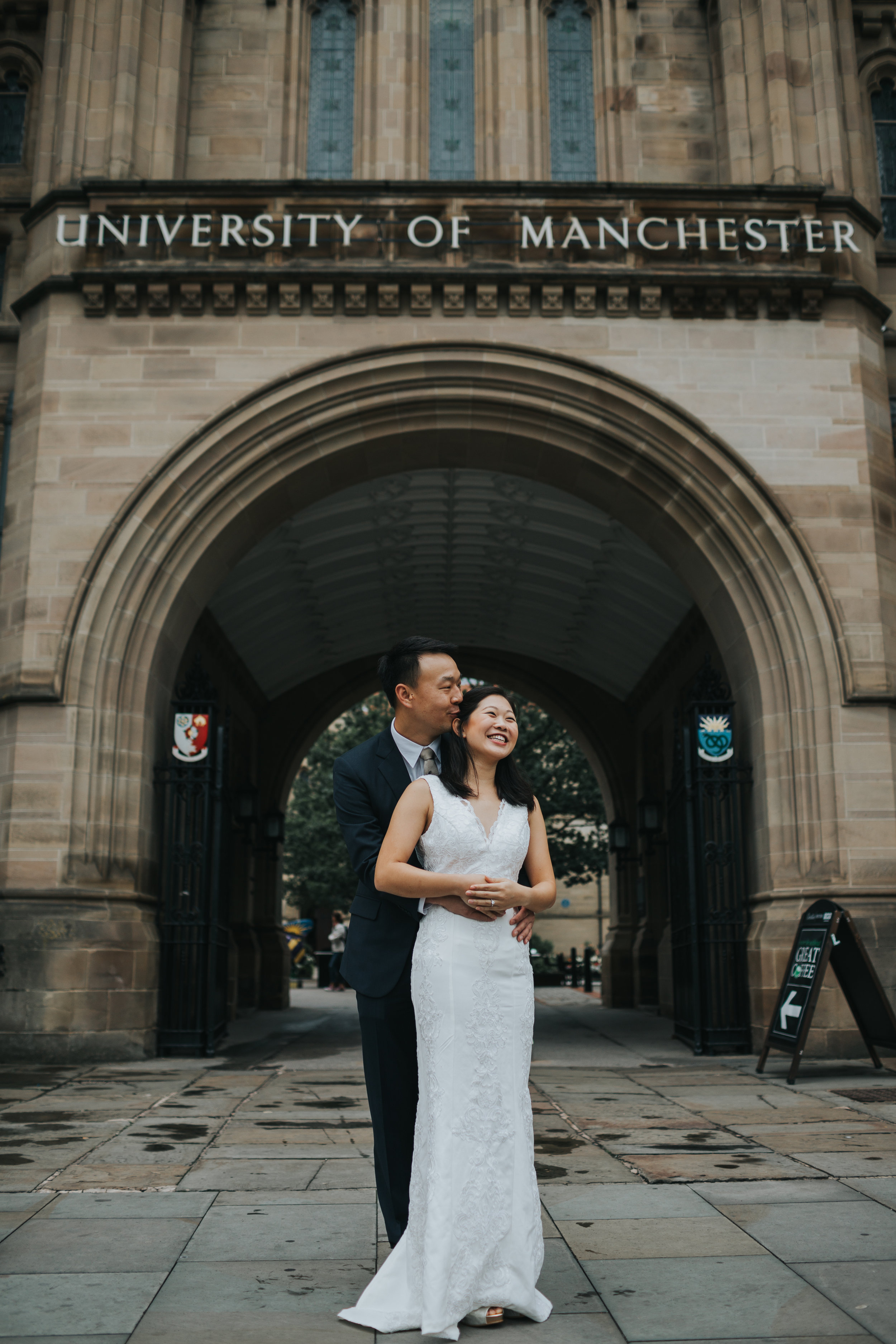 Couple have a cuddle in the Manchester university archway. 