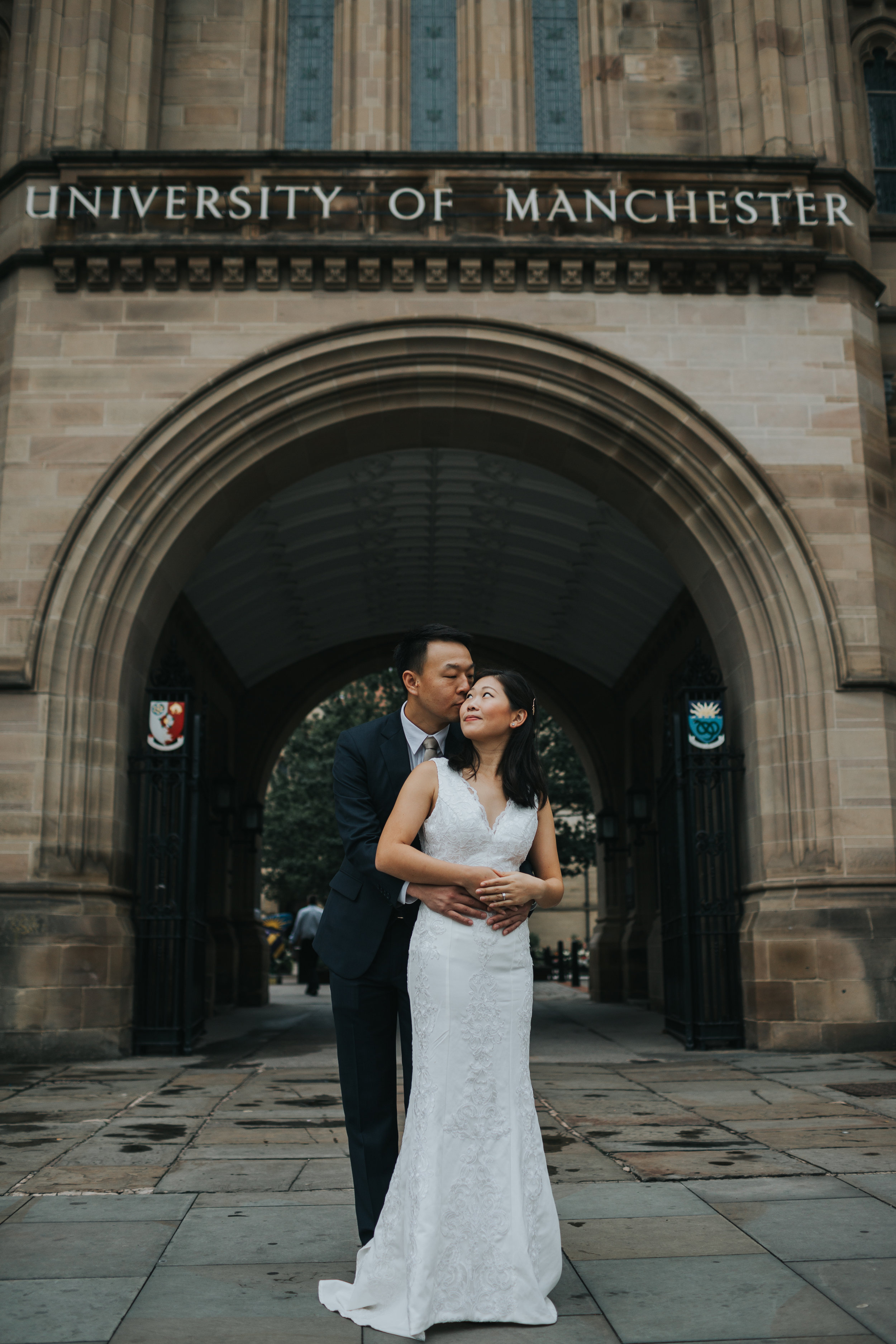 Couple embrace outside Manchester university, where they first met. 