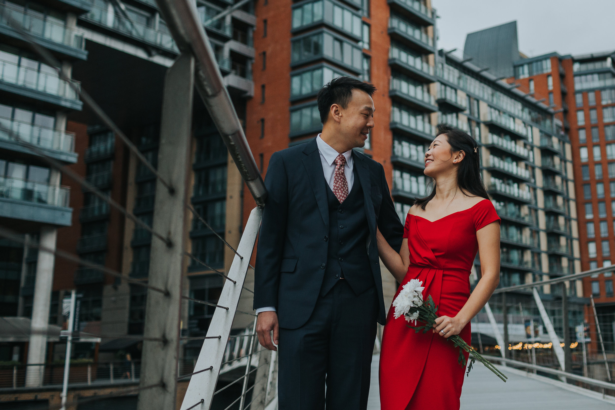 Couple laughing outside Max's old University Halls. Cristal wearing a red dress. 