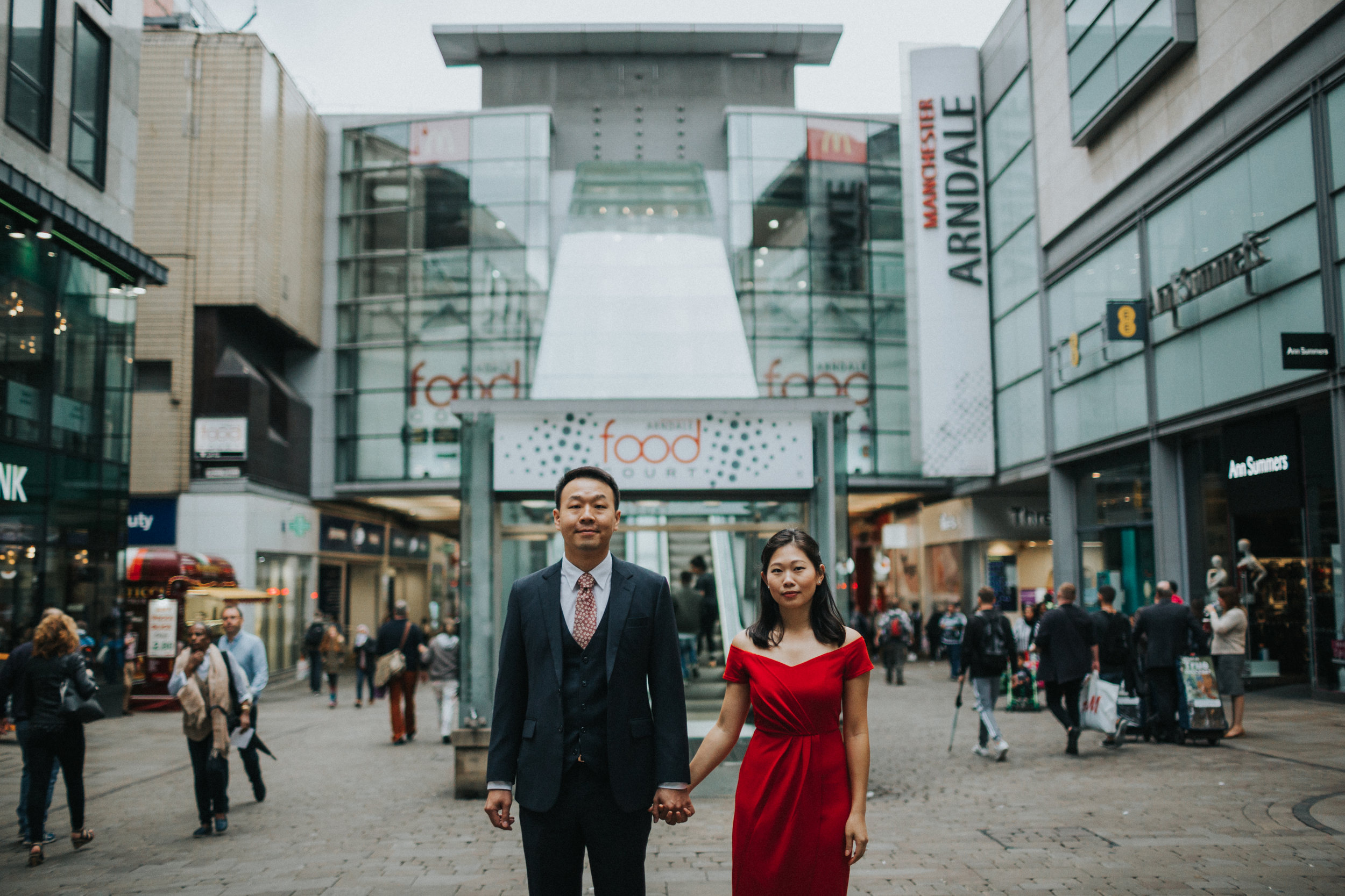 Couple stand together outside Manchester's Food Court, Market Street. 