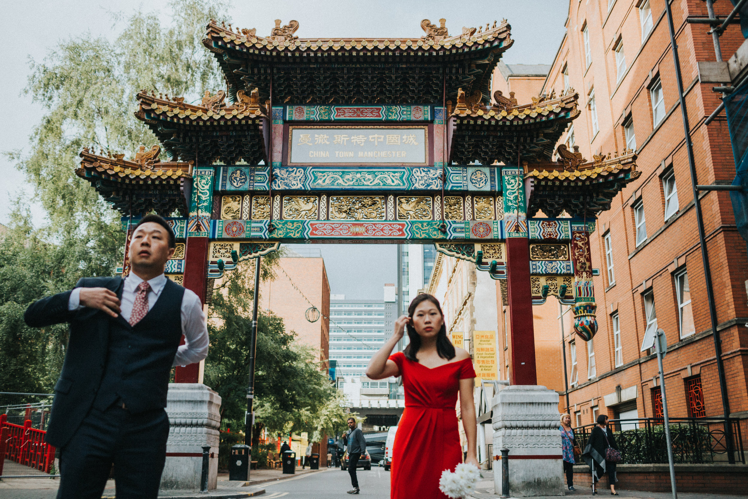 Couple get ready out side China Town Arch Manchester. Focus is on China town arch. 