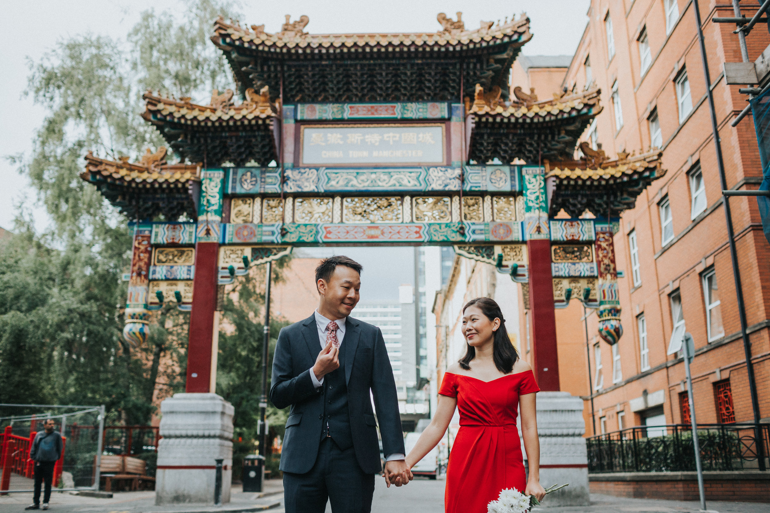 Couple stand under China Town Archway together. 