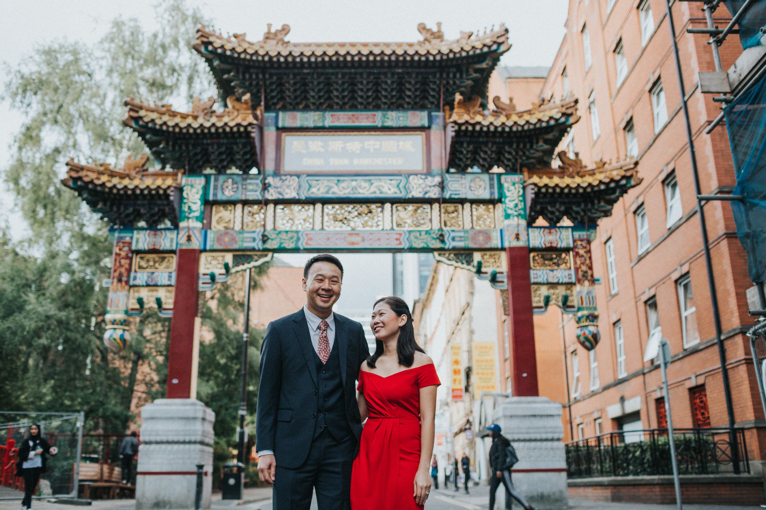 Groom laughs under China Town Arch. 