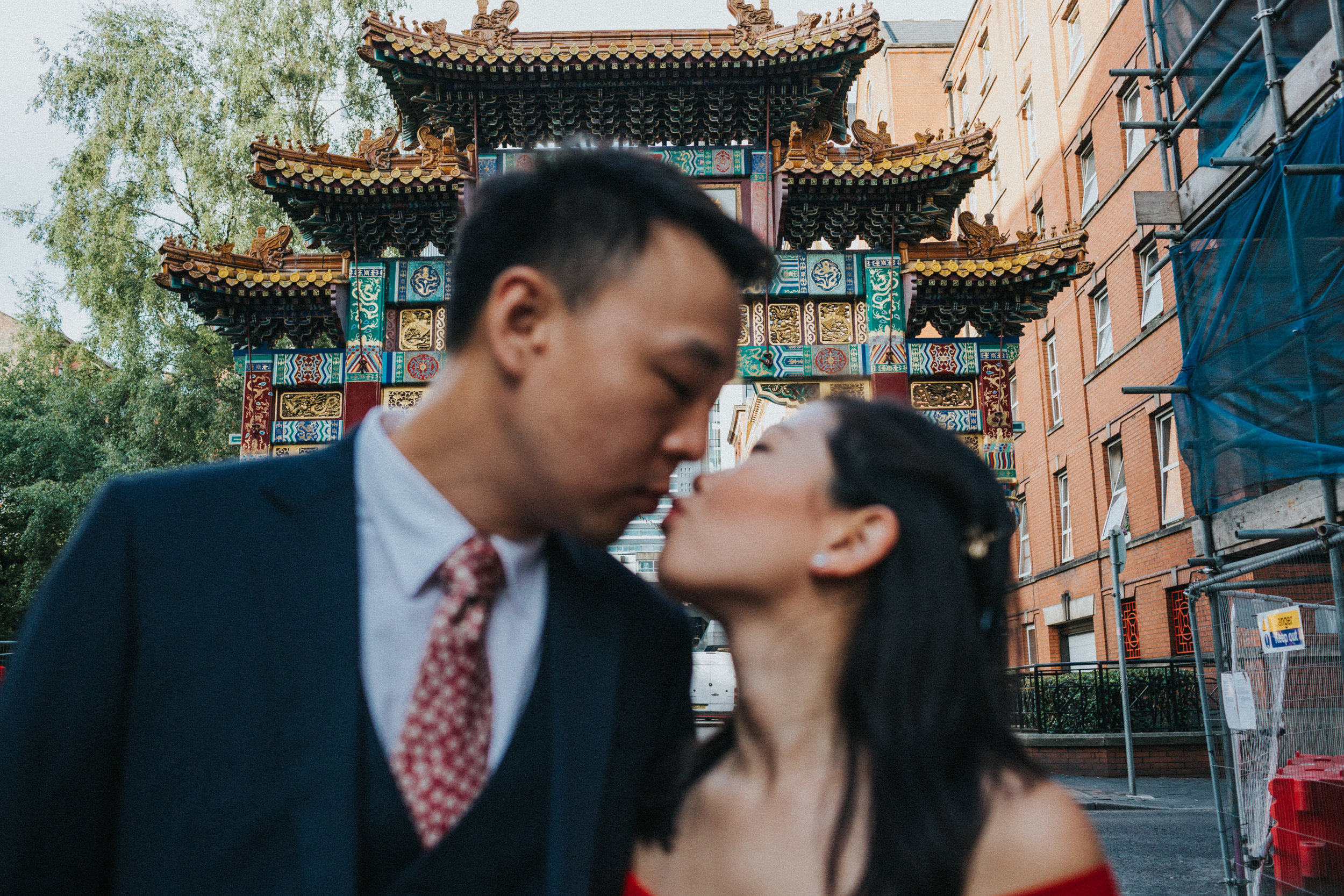 Couple kiss under China Town Archway. Focus on arch. 