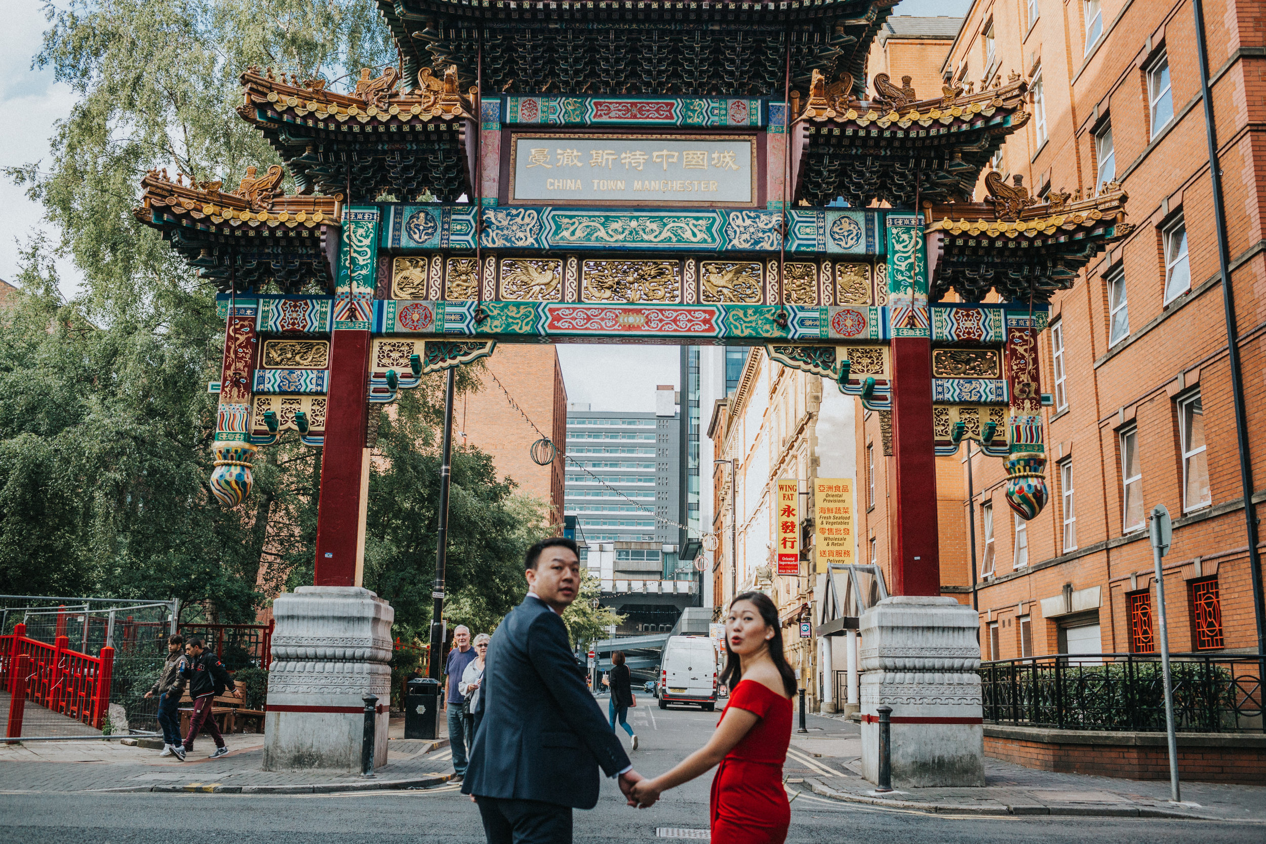 Couple walk away together taking one last look behind them. Focus on Arch. 