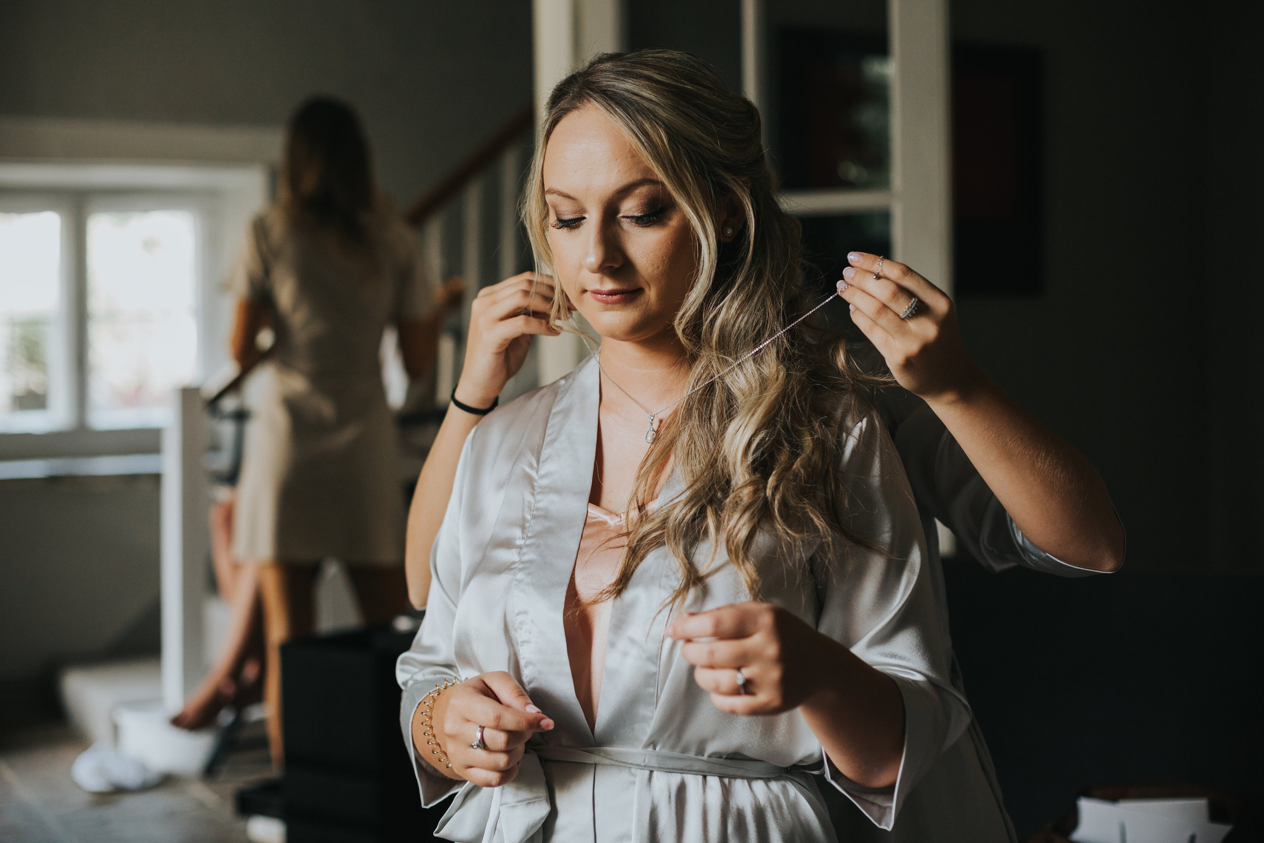 Bridesmaid has a necklace put on her.  (Copy)