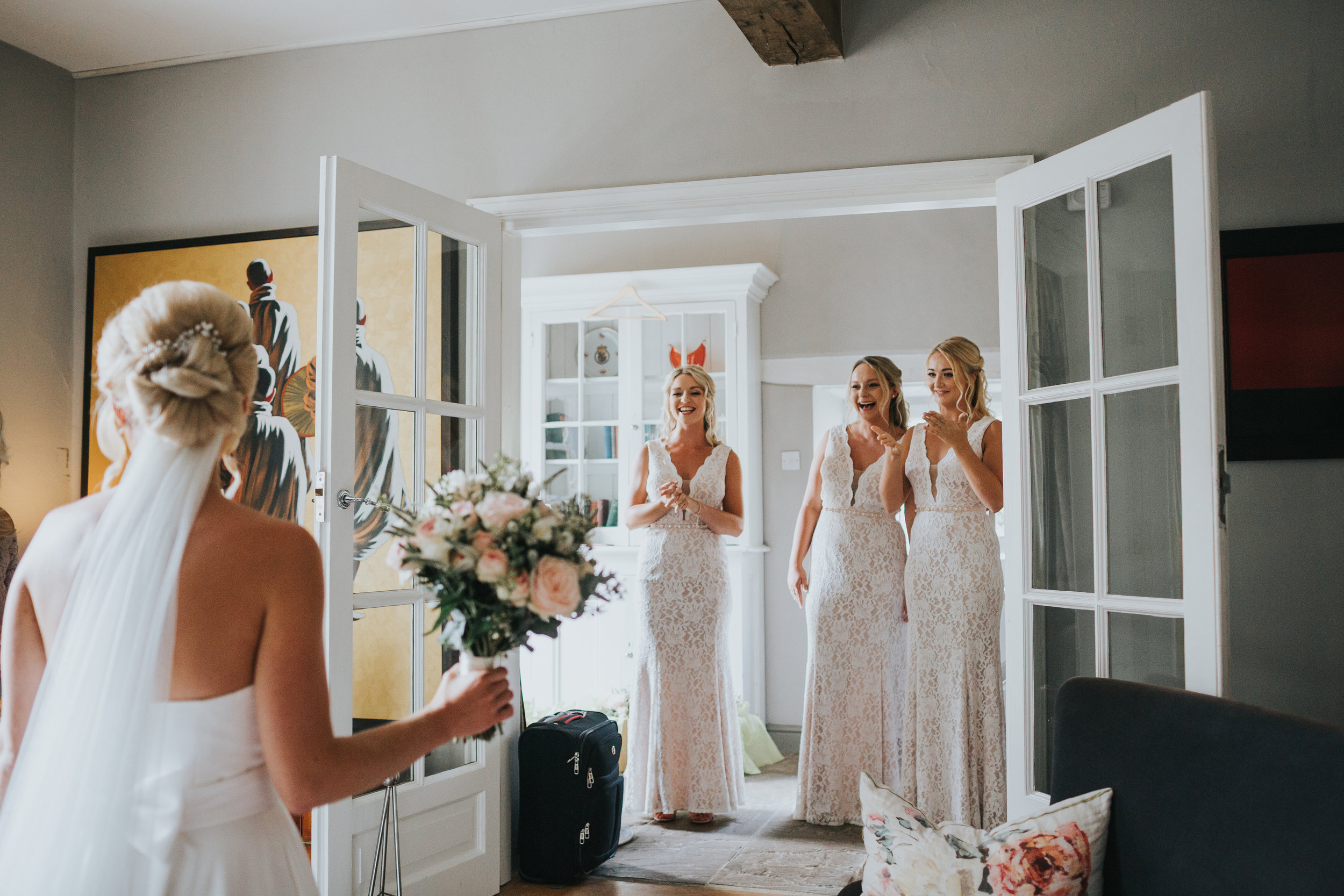 Bridesmaids see Bride in her wedding dress for the first time.