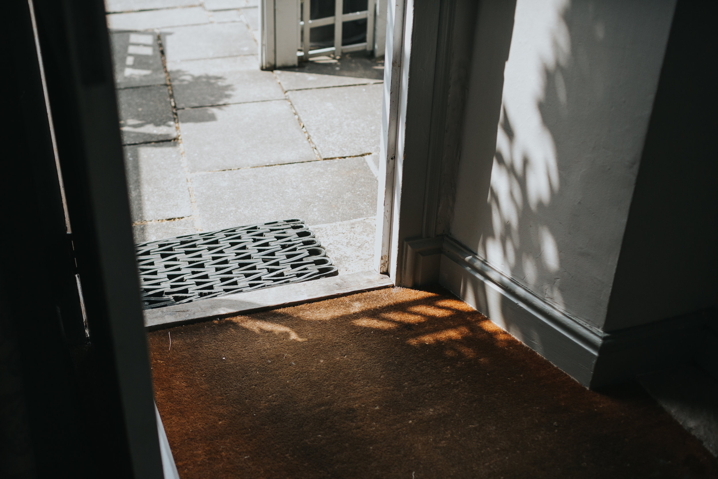 Speckled sunlight coming through the trees into the doorway.