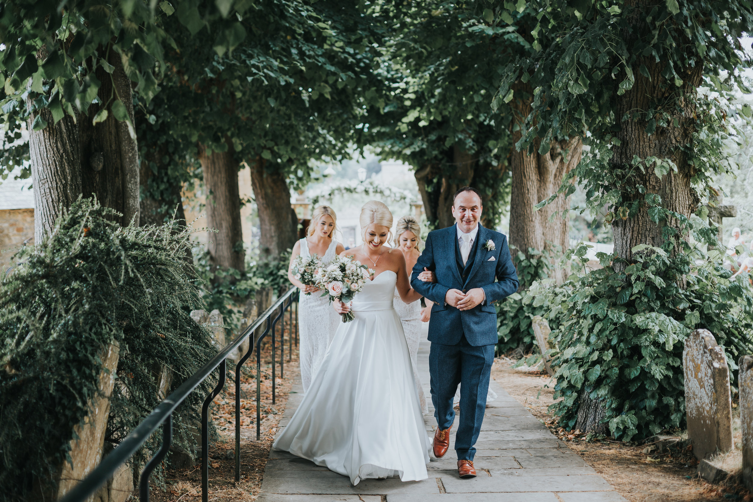 Bride walks down the church pathway with her dad.  (Copy)
