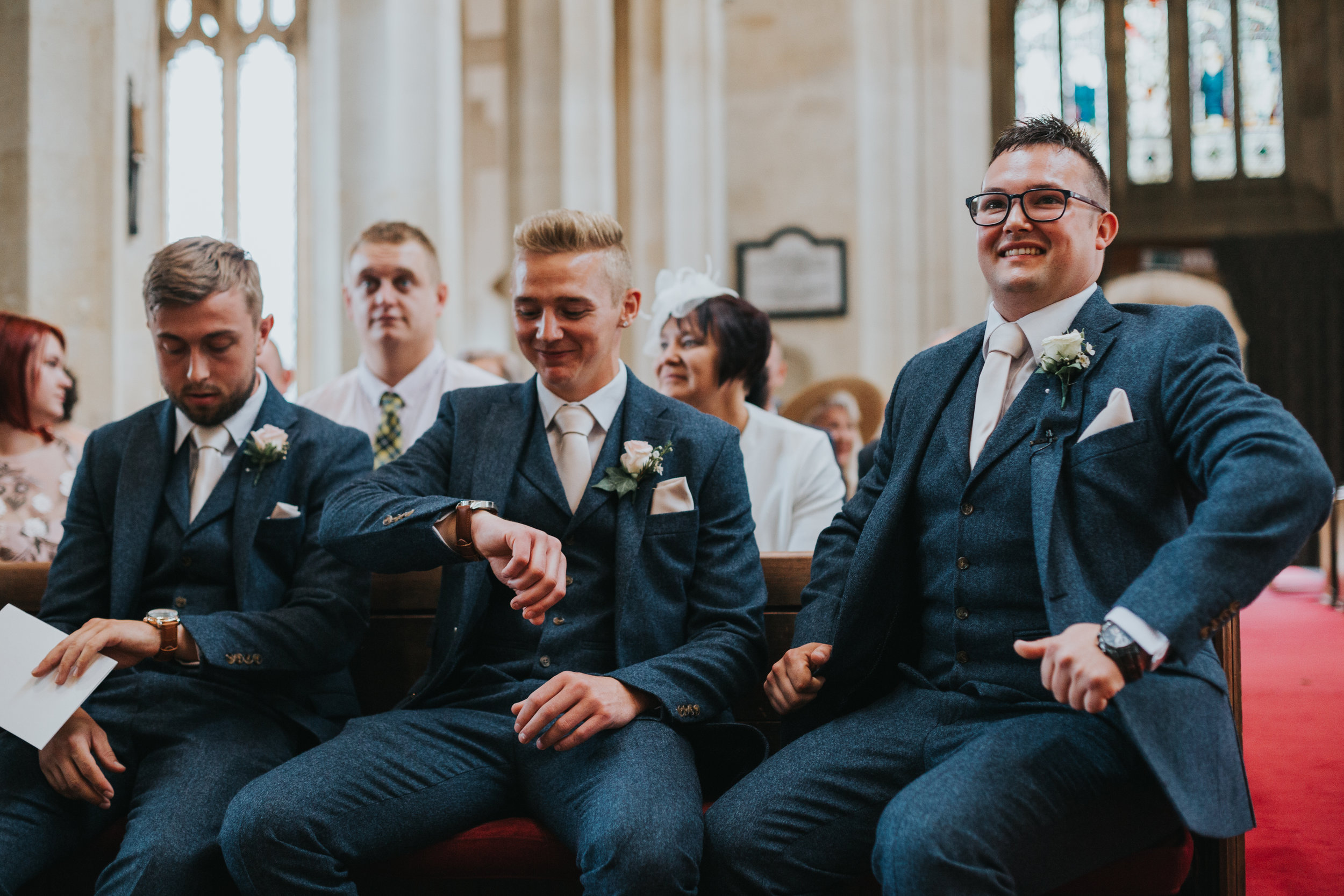 Groom waits inside the church with his groomsmen. Best Man looking at his watch.  (Copy)