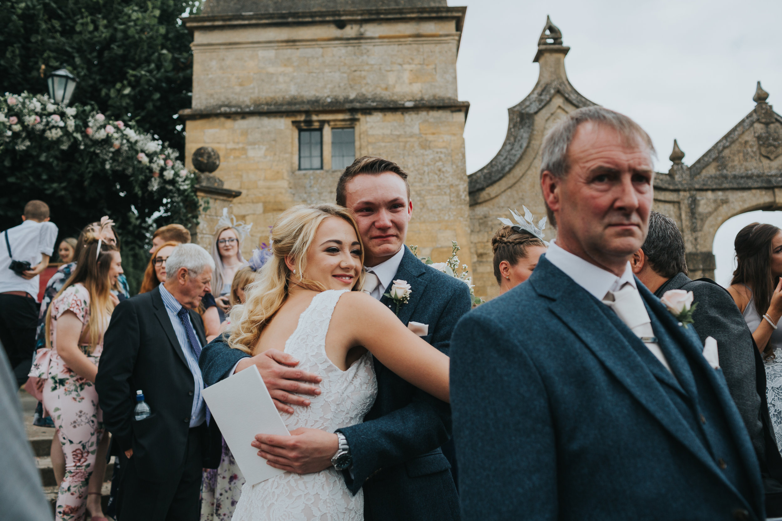 Brides sister cuddles her boyfriend outside the church where her sister has just been married.  (Copy)