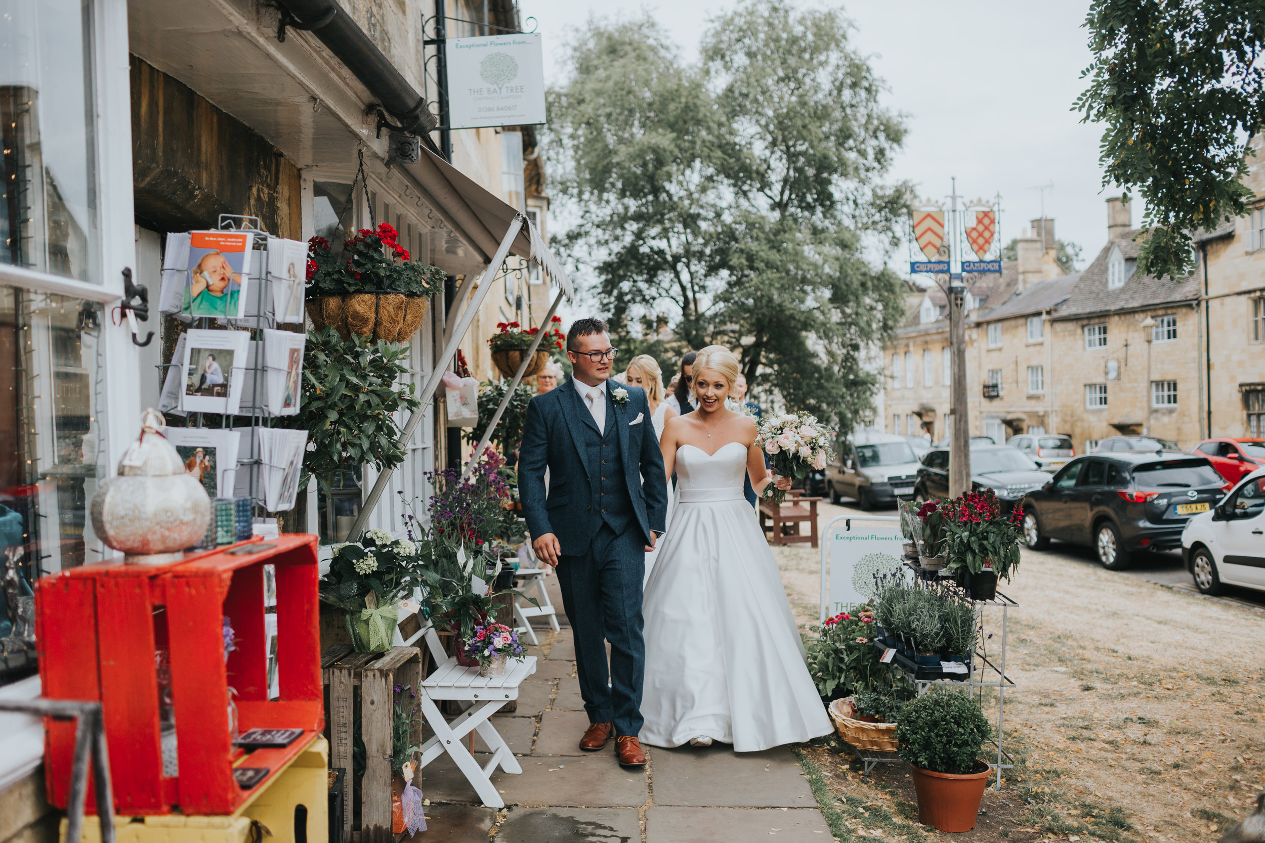 Bride and Groom walk past the local shops together.  (Copy)