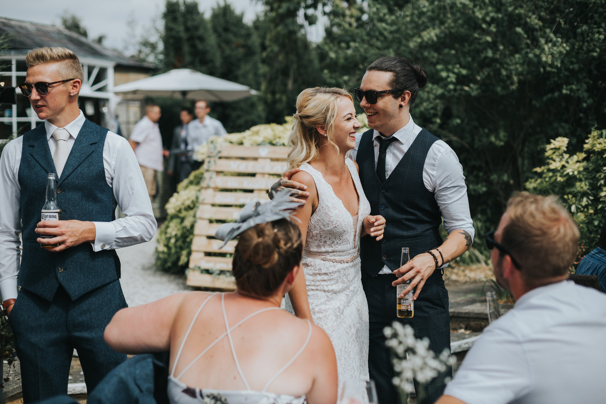 Brides sister and her boyfriend laugh together.
