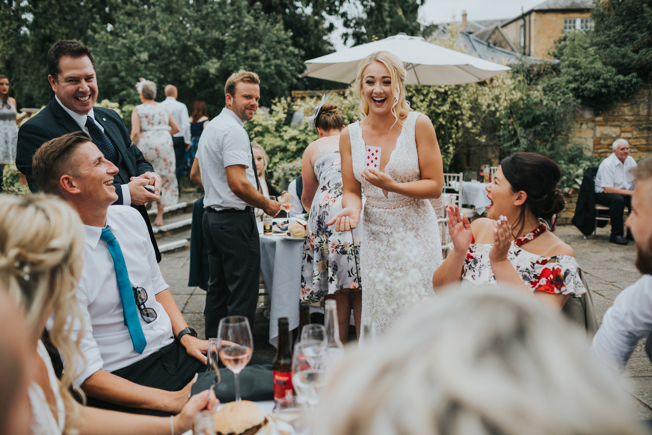 Brides sister looks excited while holding a card during a magic trick.  (Copy)