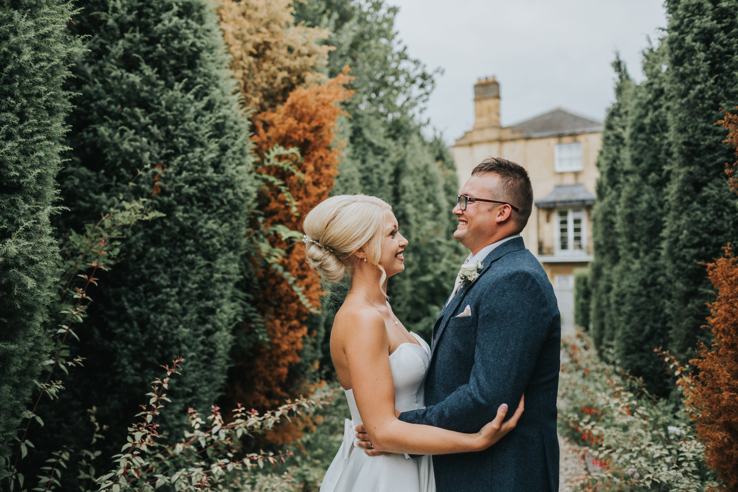 Bride and Groom hold each other laughing in Italian gardens, Cotswolds House Hotel.