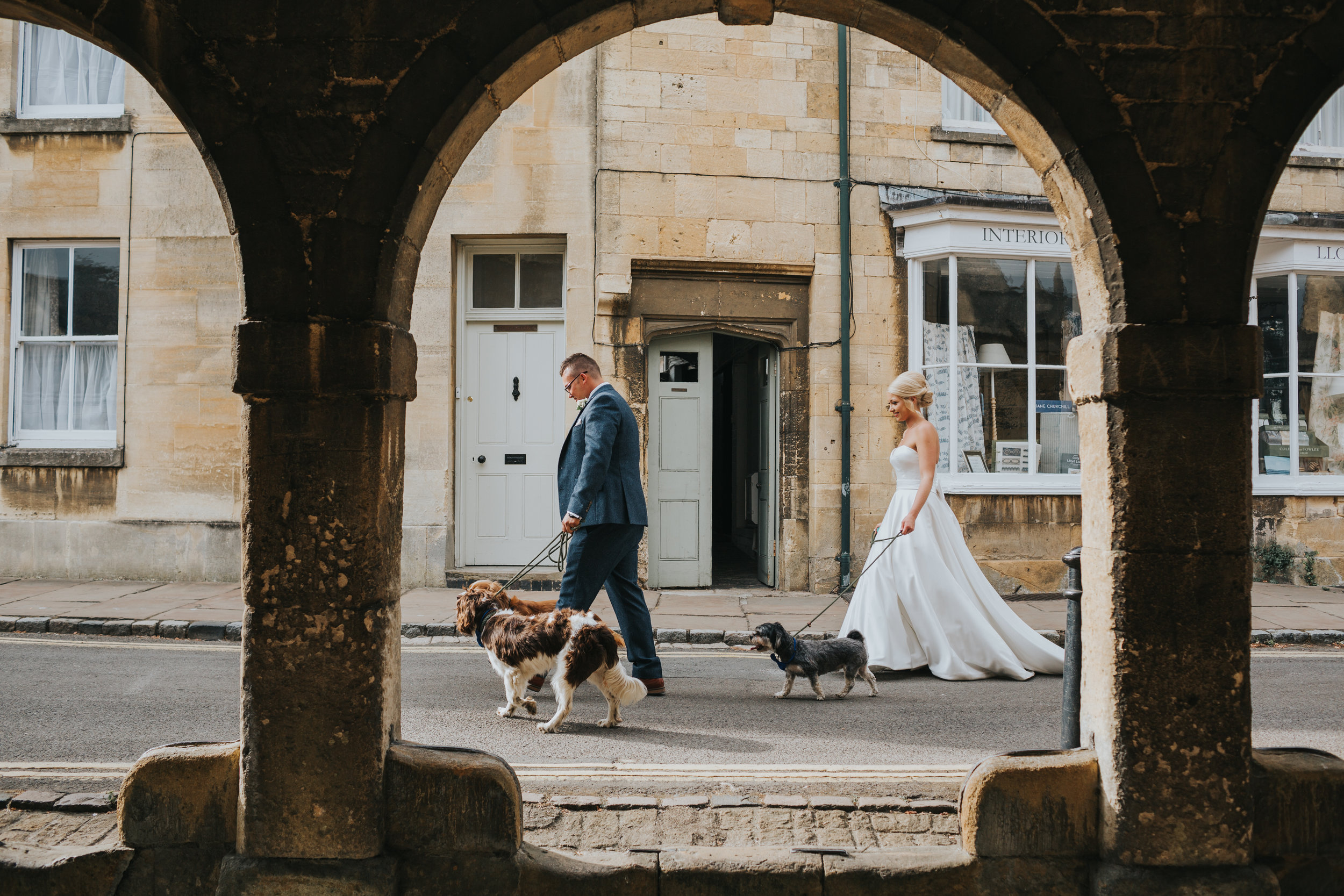 Bride and Groom walk their dogs under arches.  (Copy)