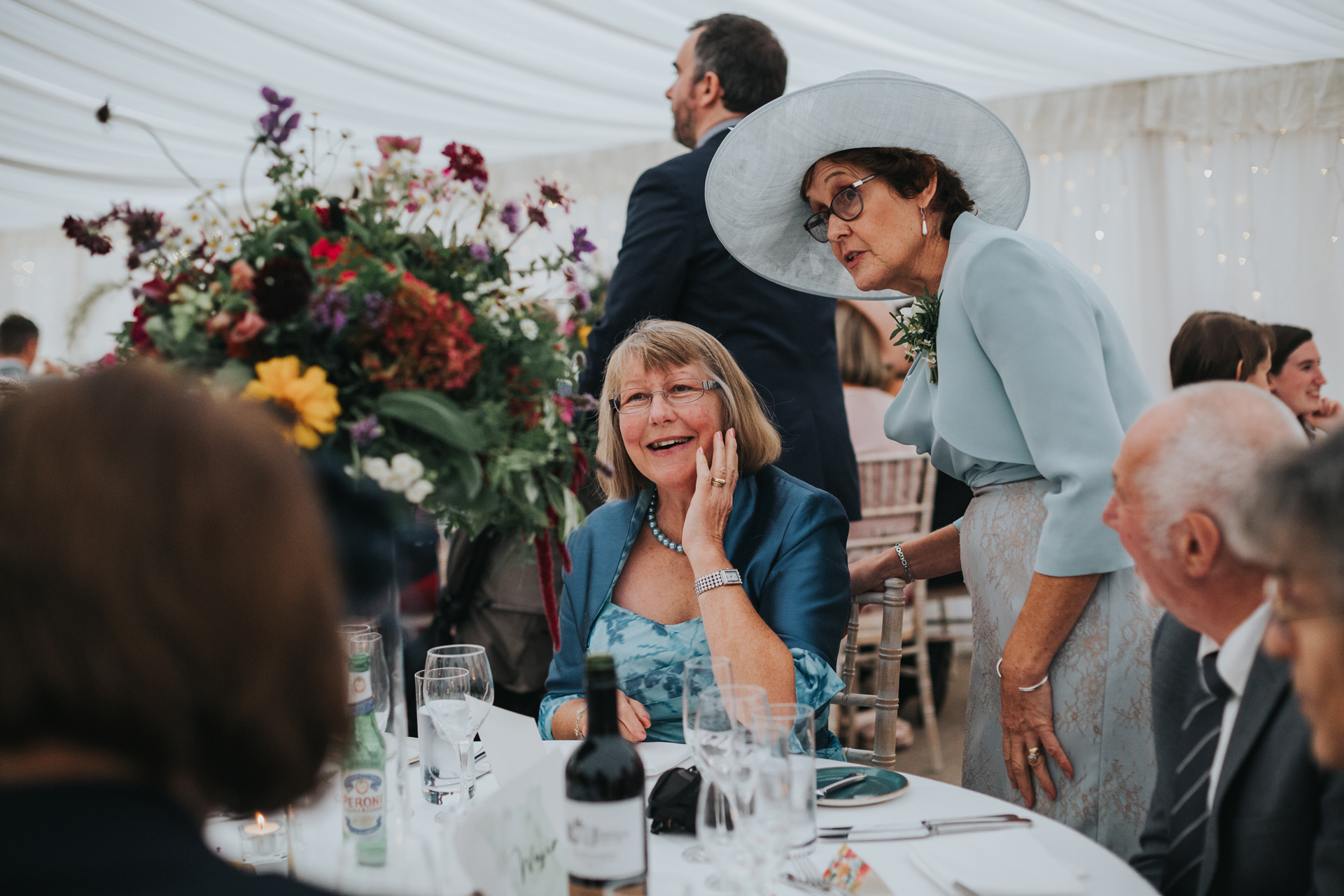 Wedding guests admire the beautiful flowers in the marquee at Goldstone Hall.