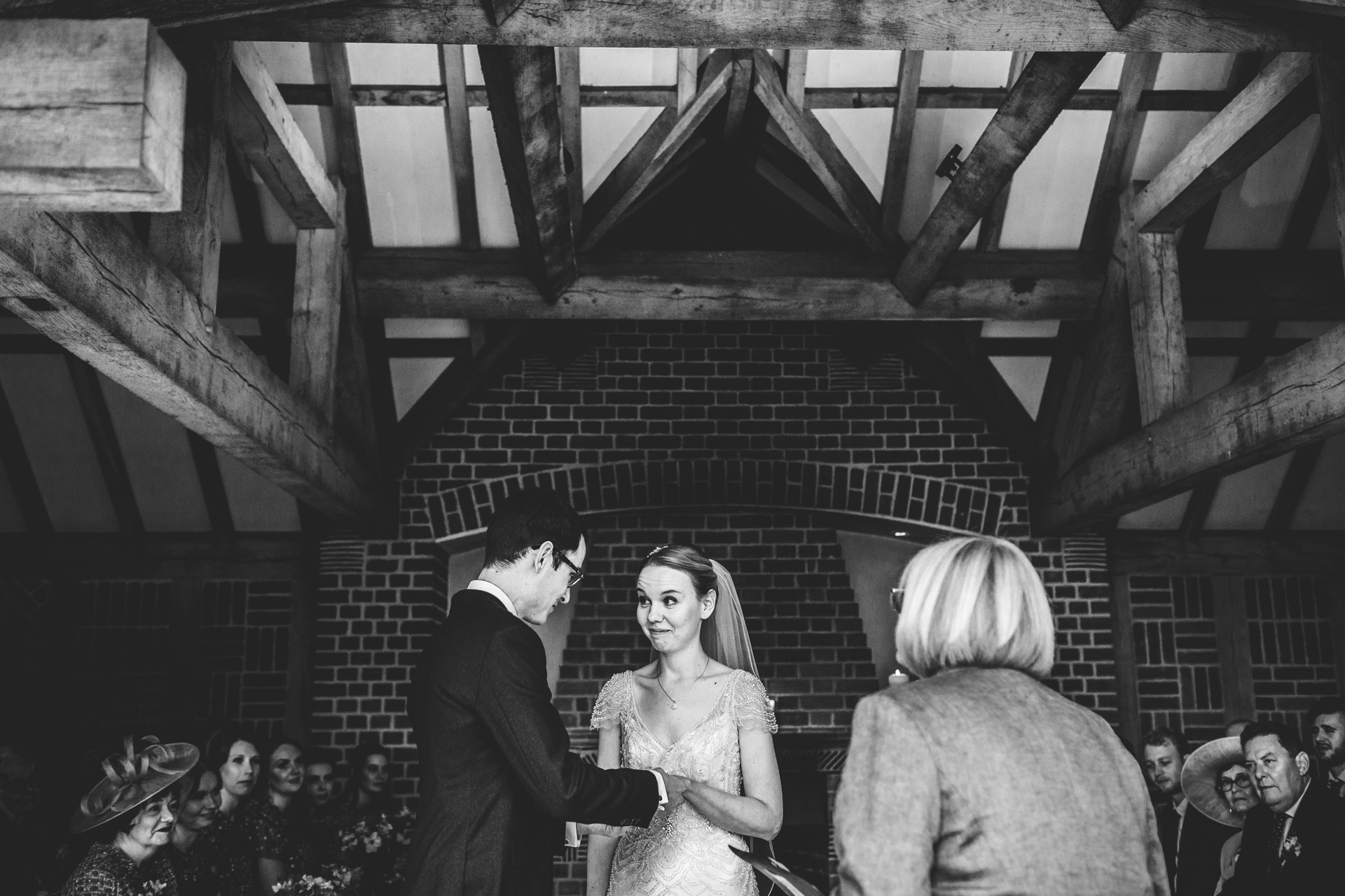 Bride and groom say their vows in an outdoor ceremony at Goldstone Hall, Market Drayton. Photograph in black and white. 