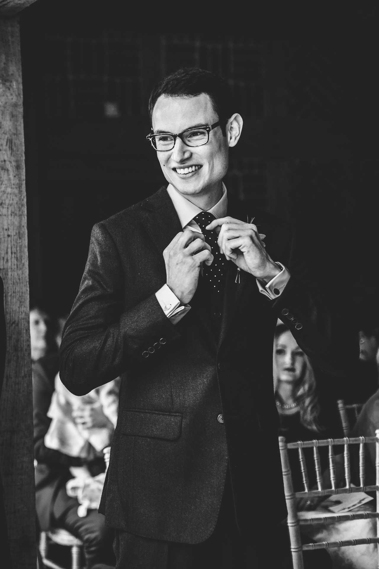 Groom fixes his tie, photograph in black and white.