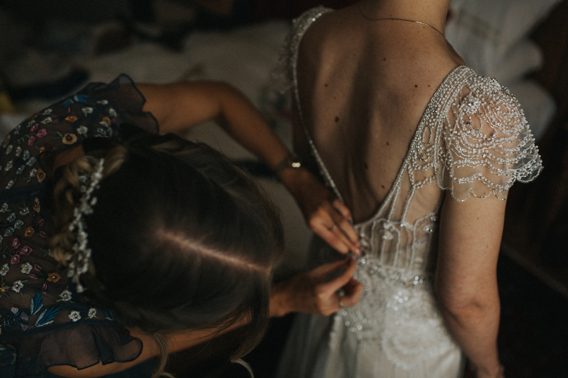 Close up of details of dress as bridesmaid fastens up the back. 