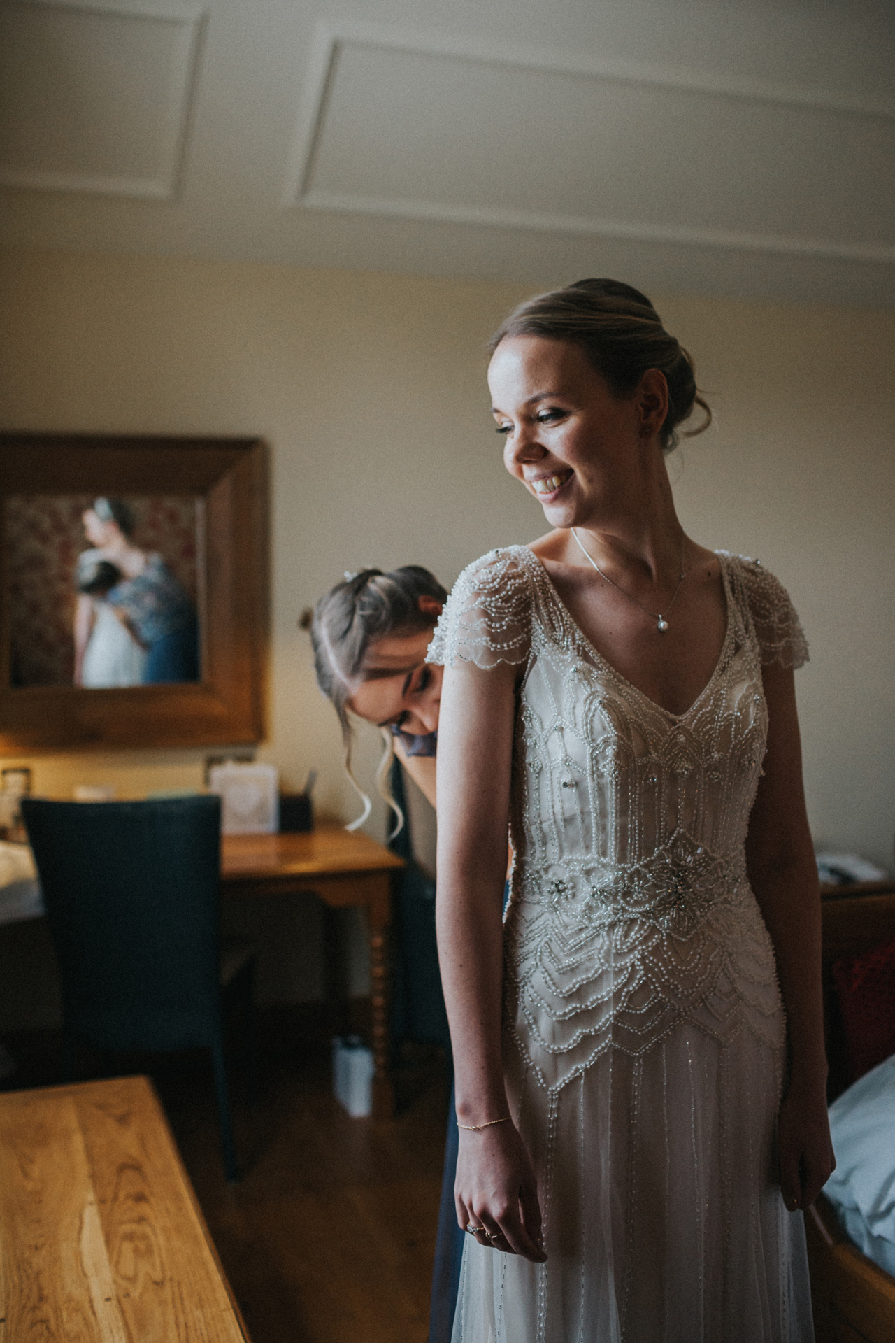 Bride stands smiling while wearing her wedding dress.