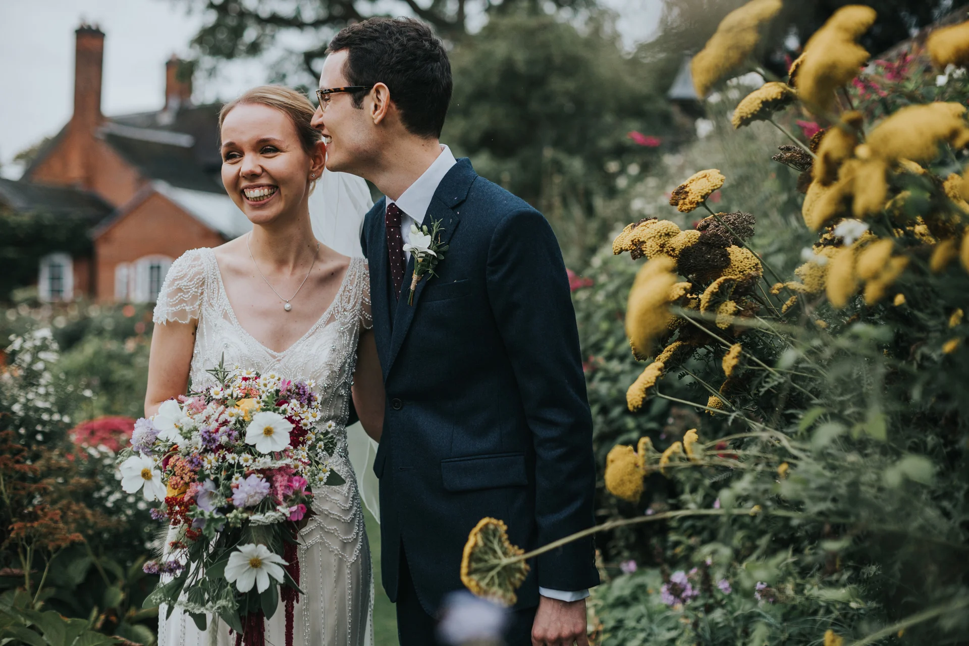 Bride and groom standing in gardens at Goldstone Hall, Market Drayton. 