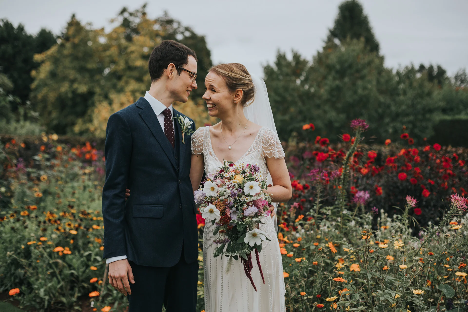 Bride and Groom stand with a sea of colourful wild flowers together at Goldstone Hall, Market Drayton. 