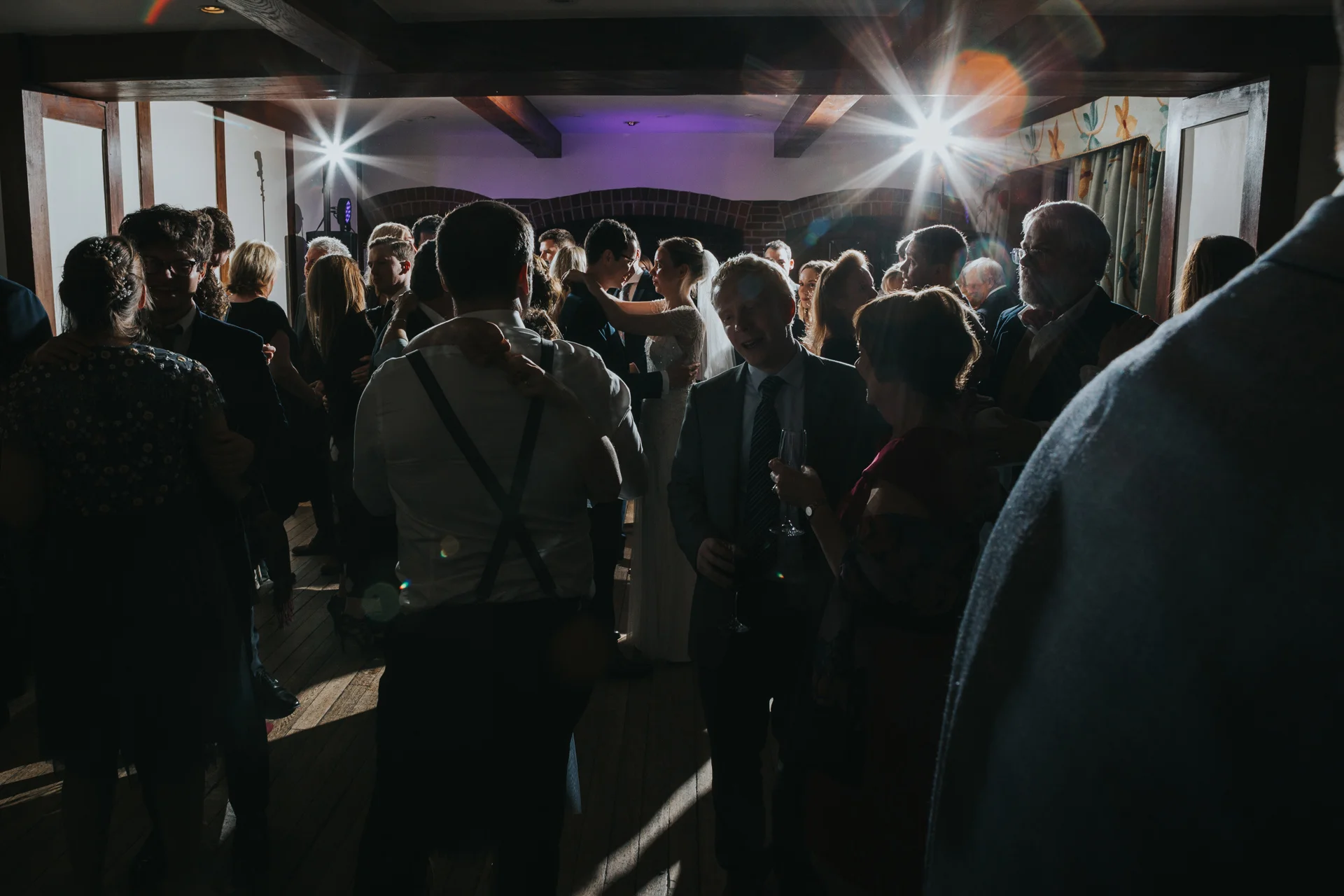 Bride and Groom dance together in the centre on the dance floor surrounded by their friends and family at Goldstone Hall, Market Drayton. 