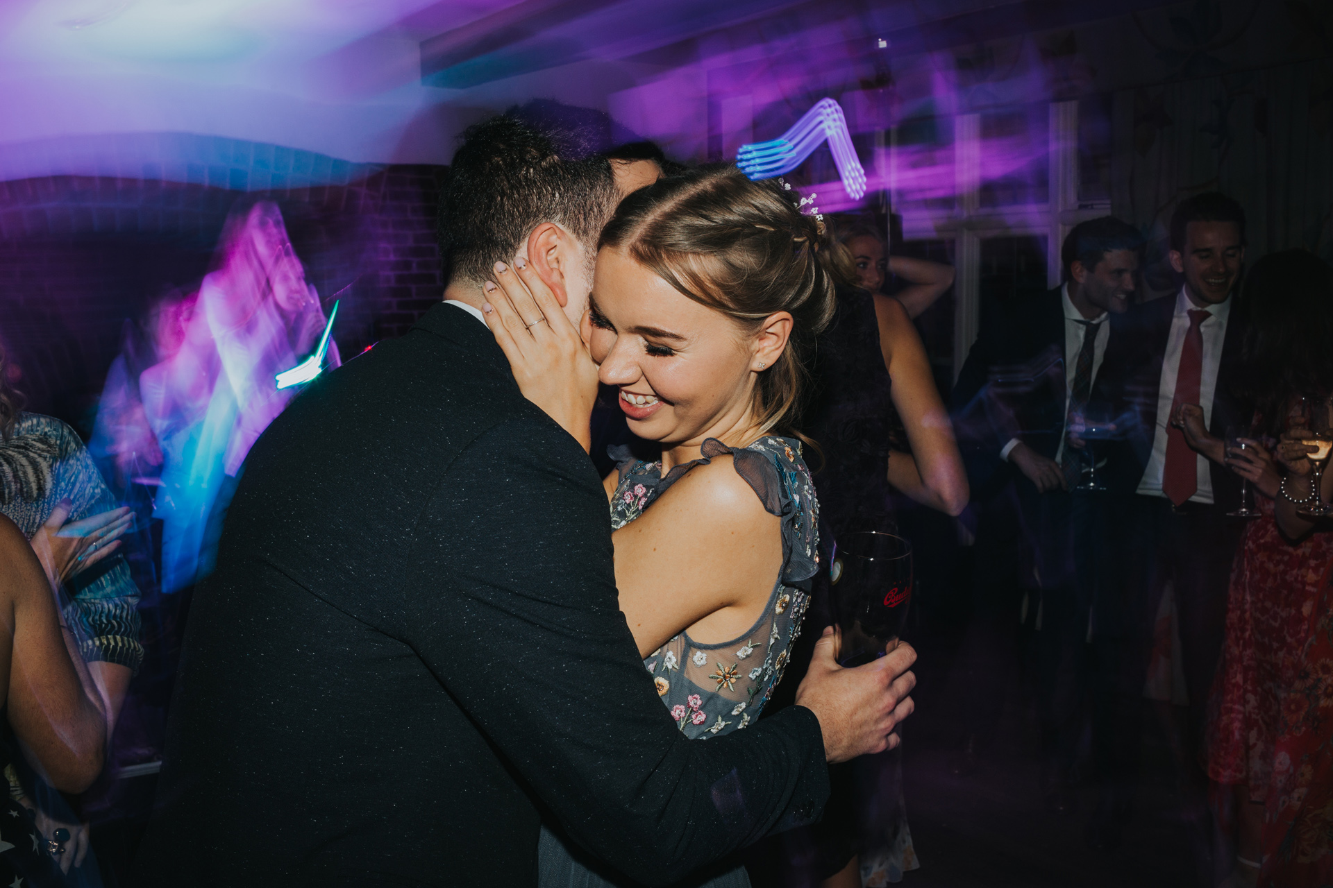 A couple cuddle on the dance floor.