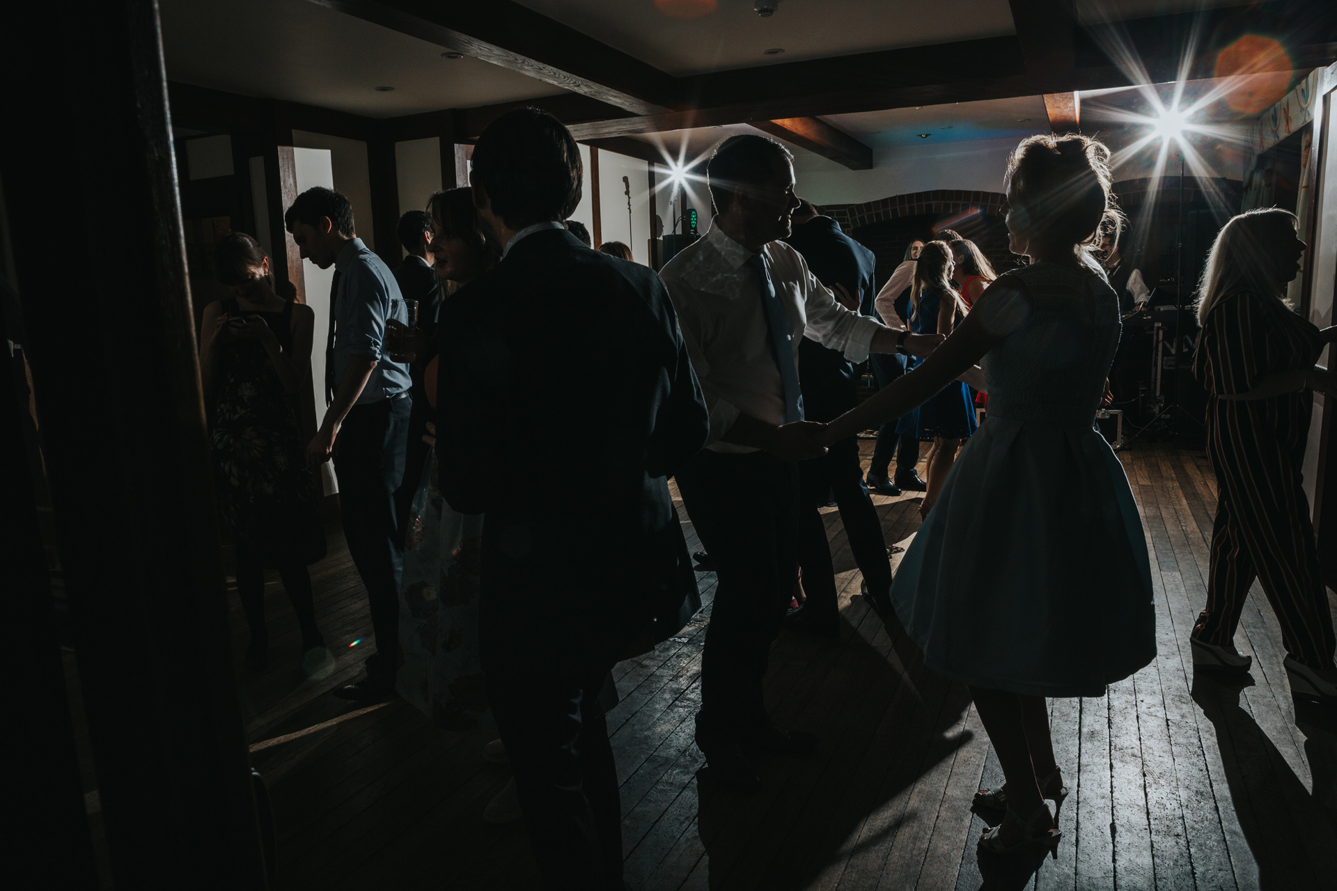 Couple are silhouetted while they dance together, female guests wears a 50's type dress. 