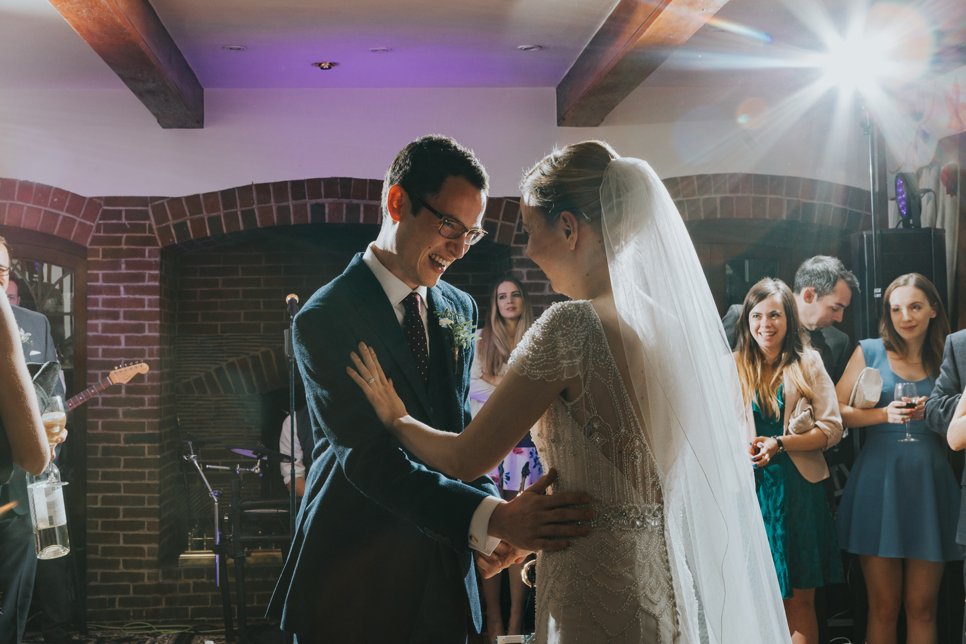 Bride and groom dance laughing together.