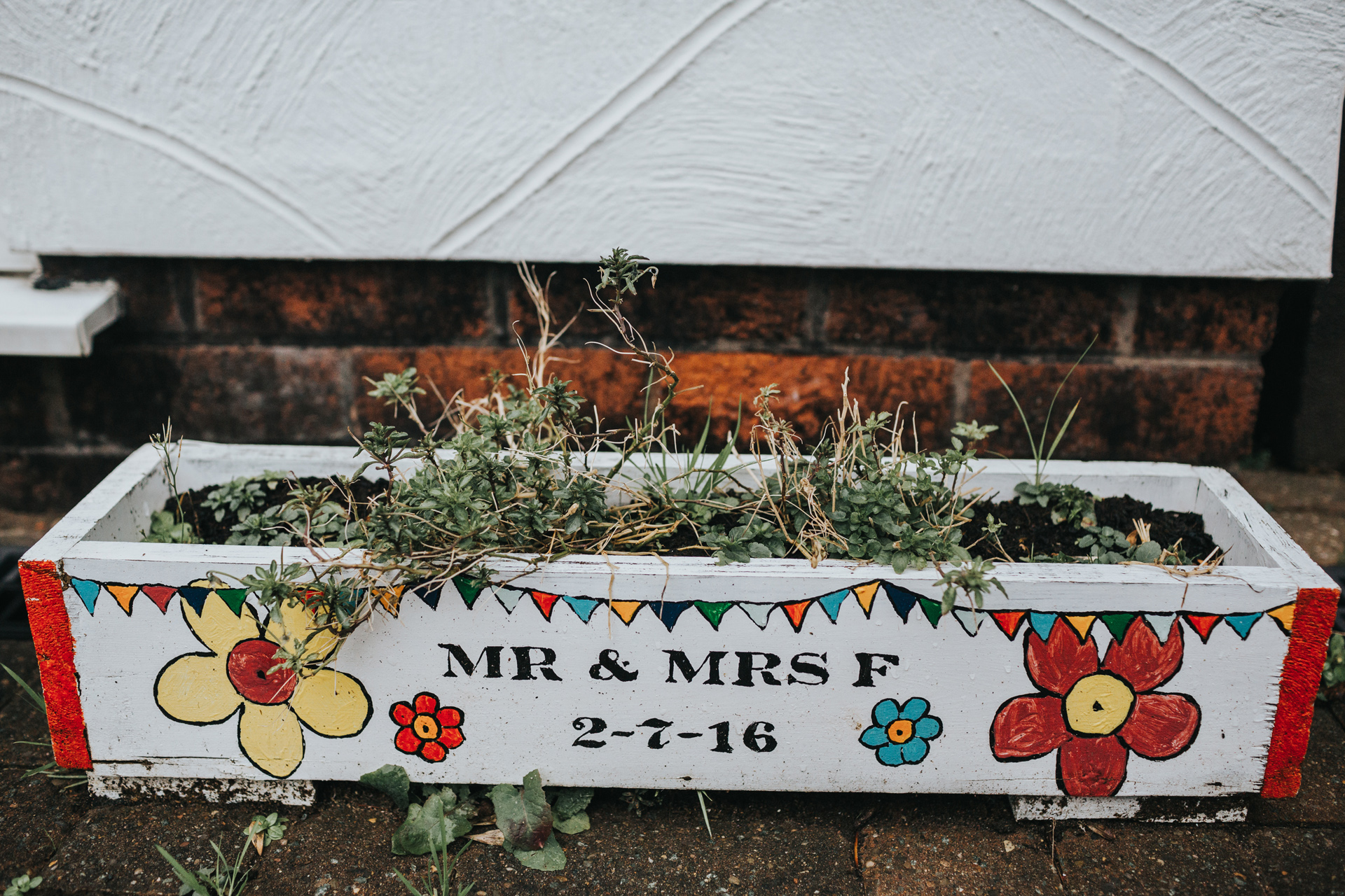 Plant pot decorated with "Mr and Mrs F" outside the family home. 
