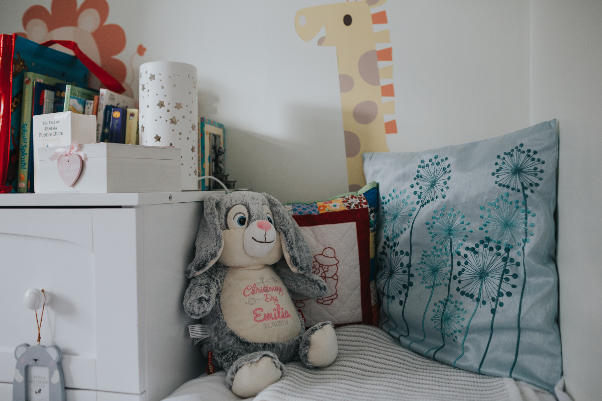 A fluffy toy bunny rabbit sits alongside other toys in the child's bedroom. 