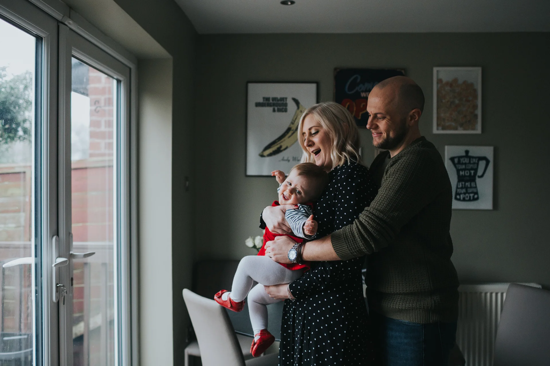 Photographer tried to get family in an awkward pose by the kitchen window but the child is having non of this rubbish! 