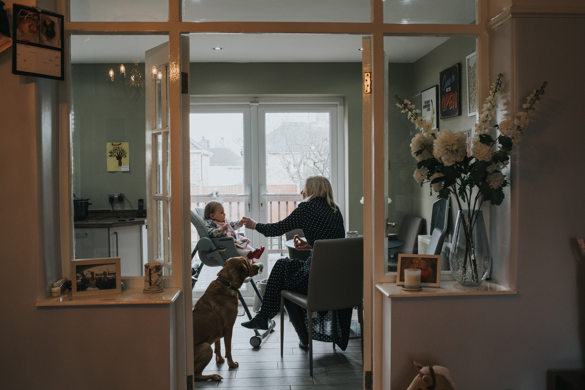 Mother feeds her baby in the kitchen. 