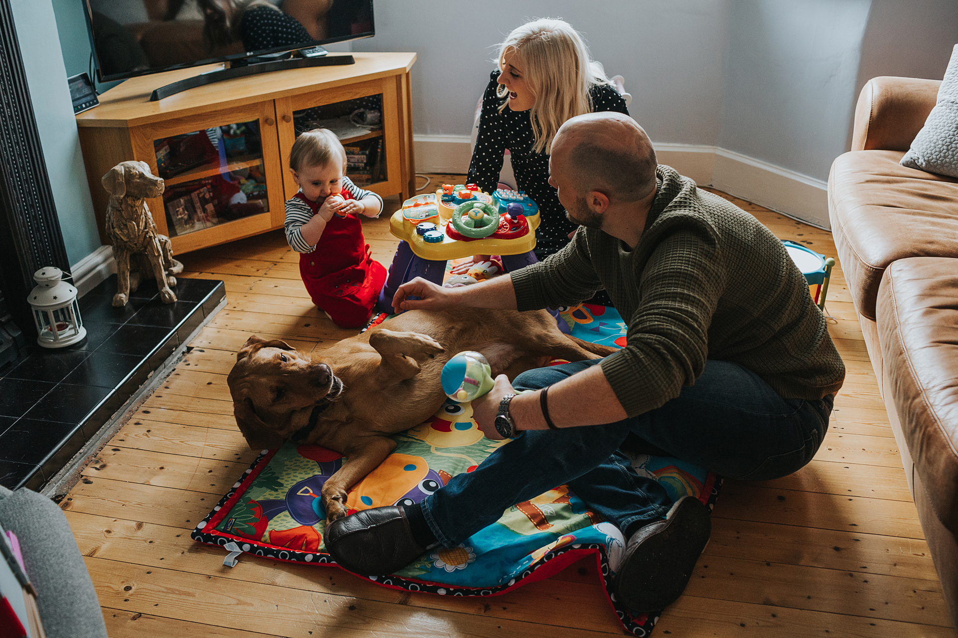 Family play together on the living room floor.