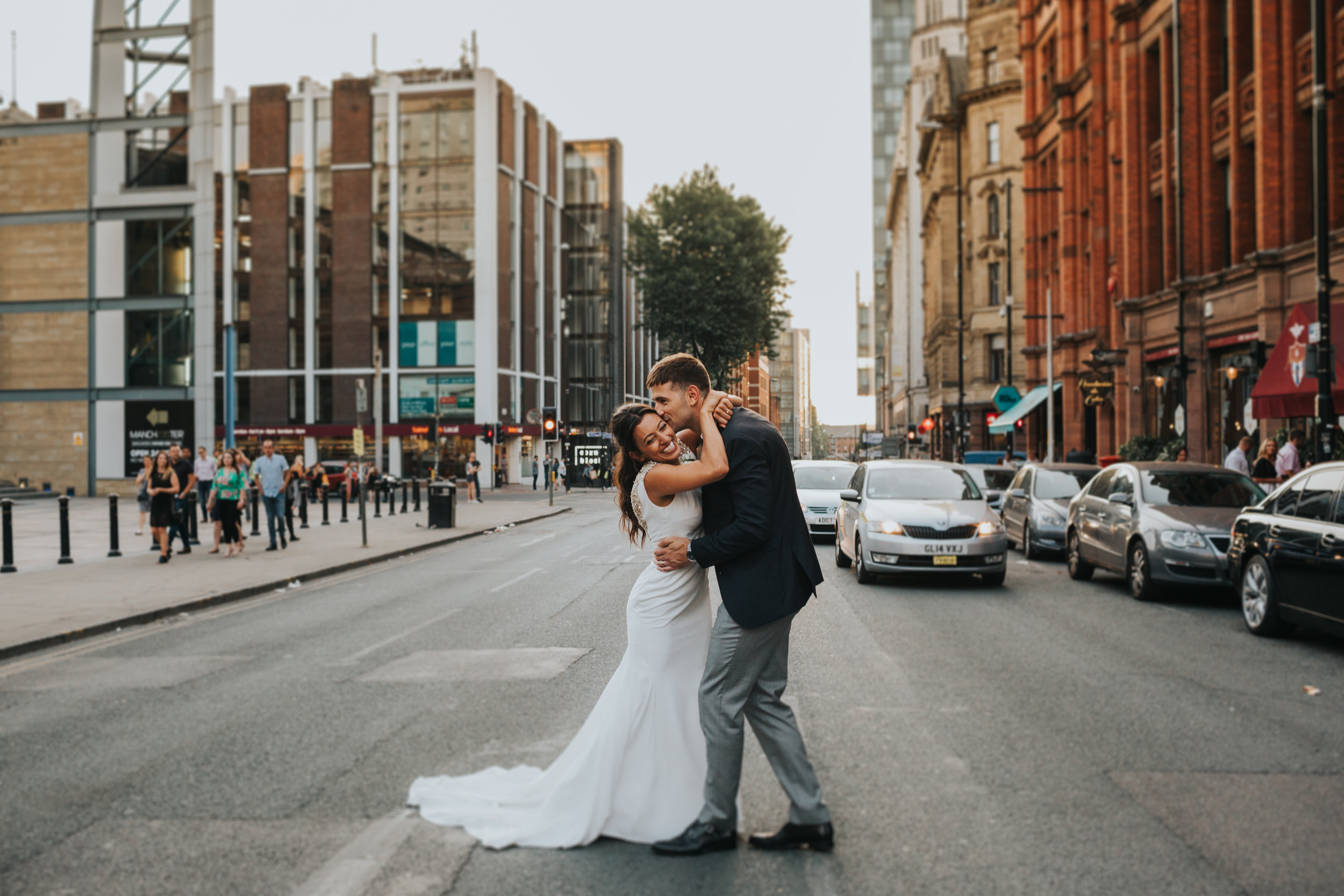 Couple kiss in the street outside Albert Hall Manchester on their wedding day. 