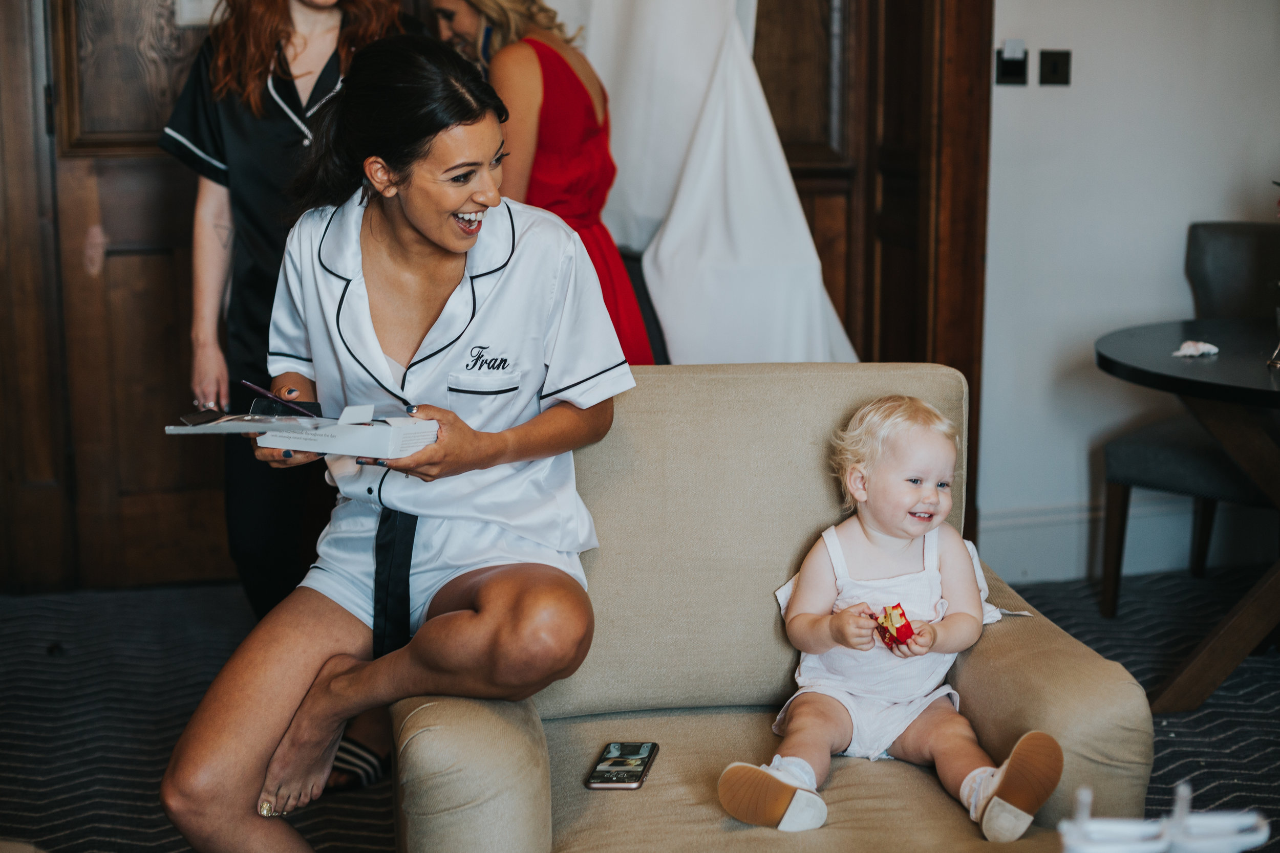 Bride sits with her niece and laughs. 