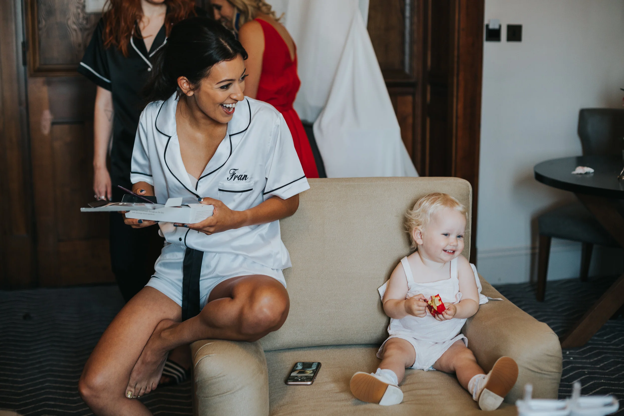 Bride sits with her niece and laughs.