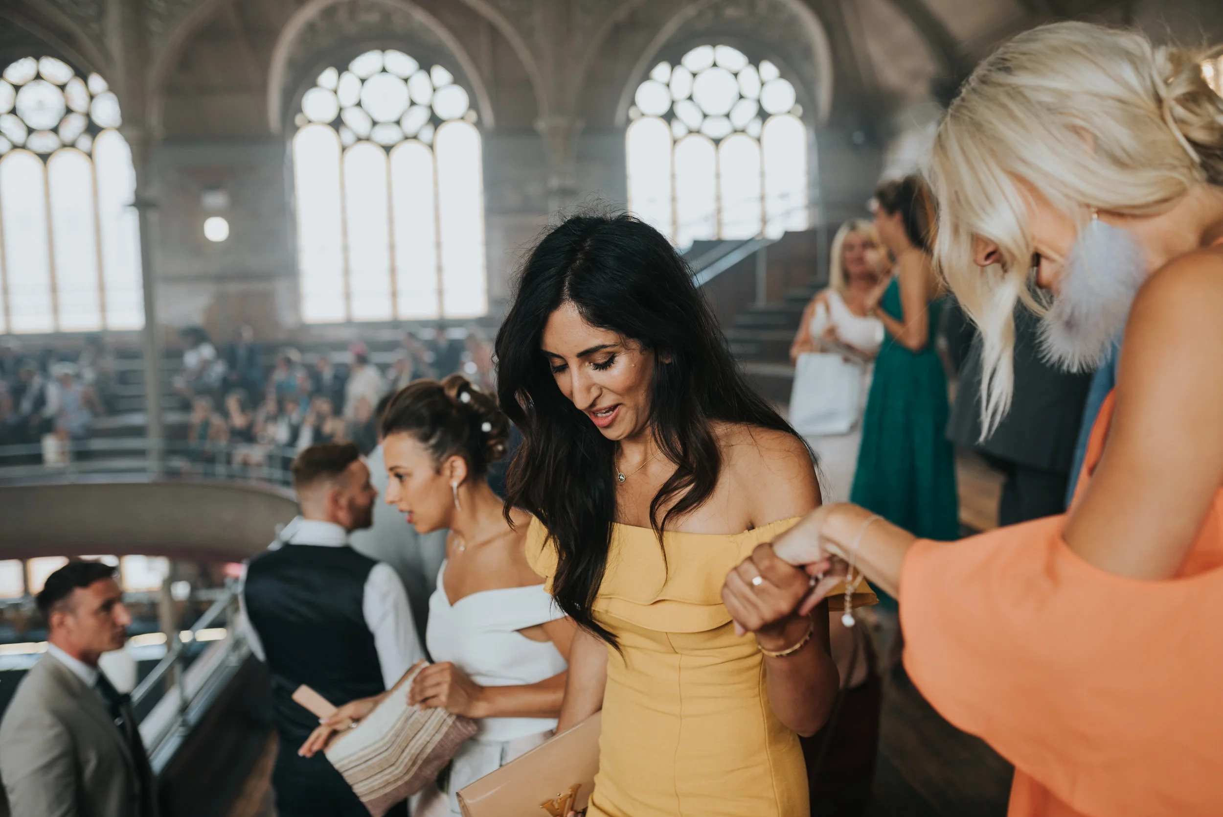 Wedding guest in yellow is helped to her seat in the stalls at the Albert Hall Manchester.