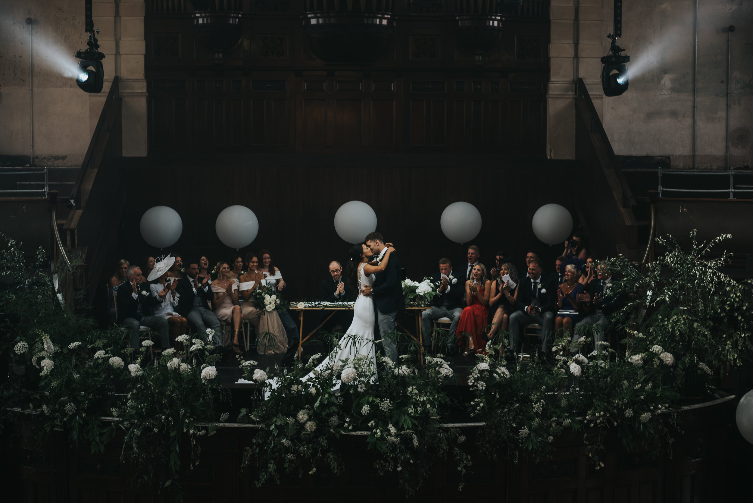 The bride and groom kiss, centre stage at the Albert Hall in front of their friends and family. 